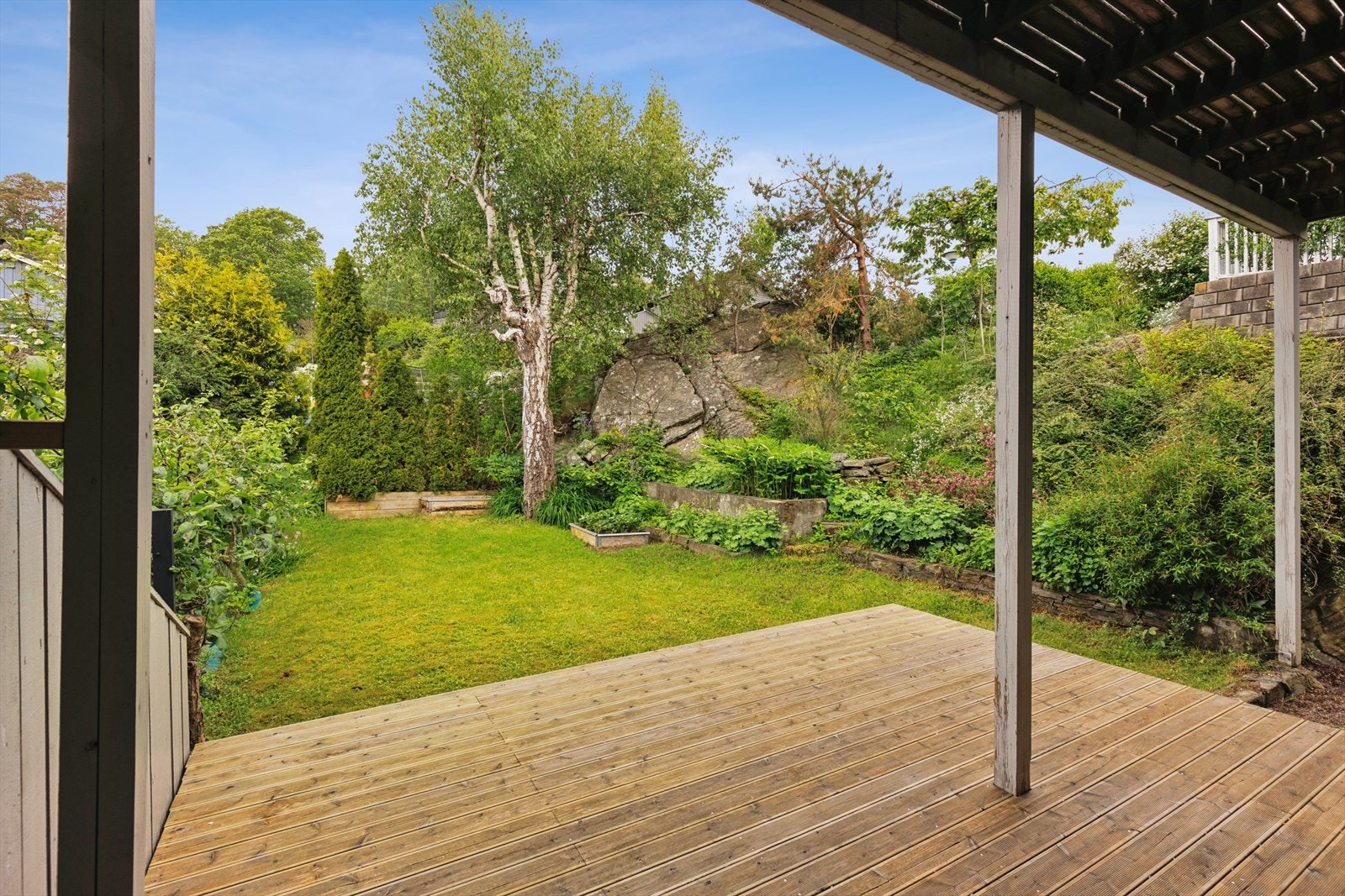 Fra første etasje er det utgang til en terrasseplatting og en skjermet hage. Boligen har en skjermet hage og flere terrasser. Galleribilde