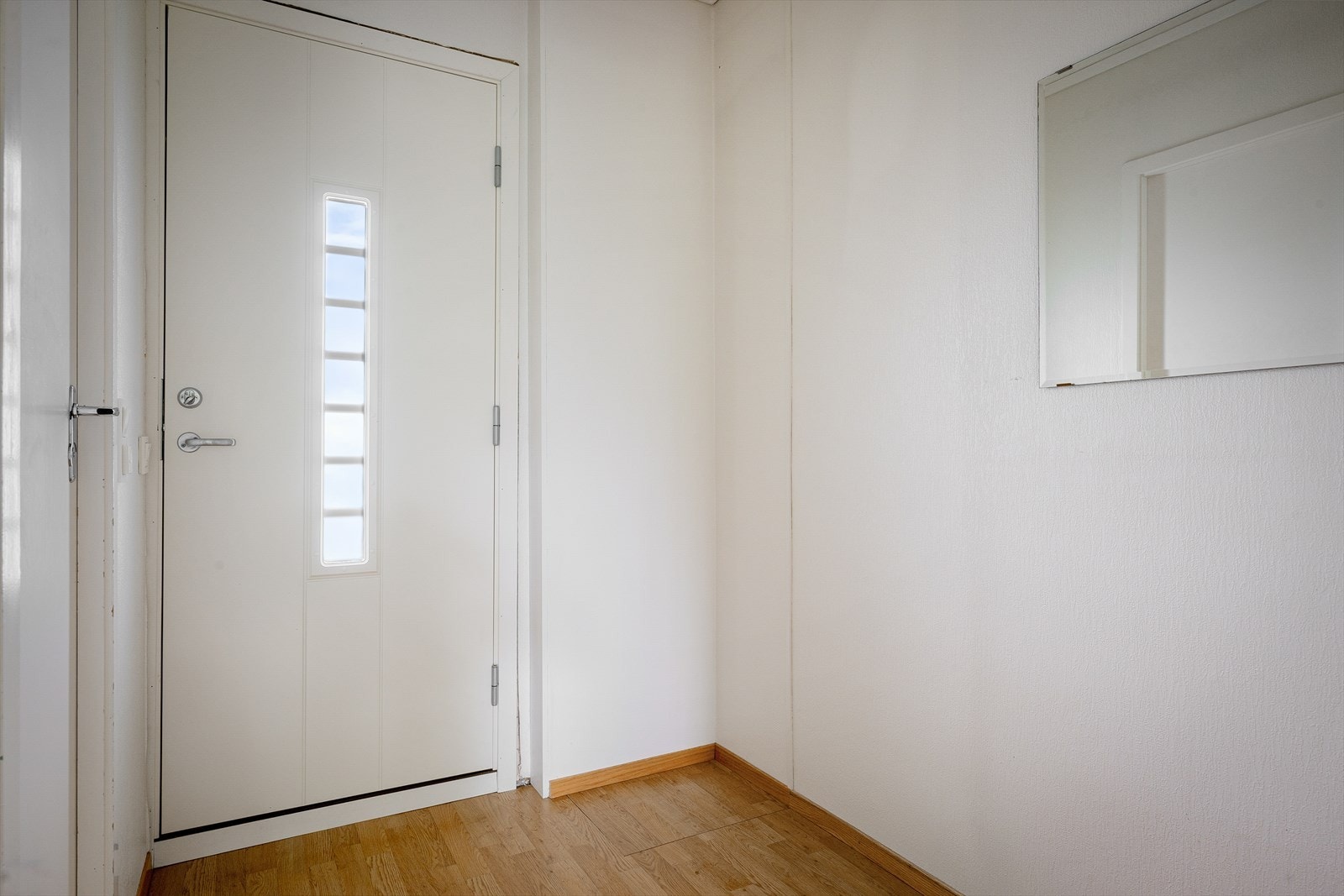 Entré med fabrikkmalt ytterdør og laminatgulv. Galleribilde