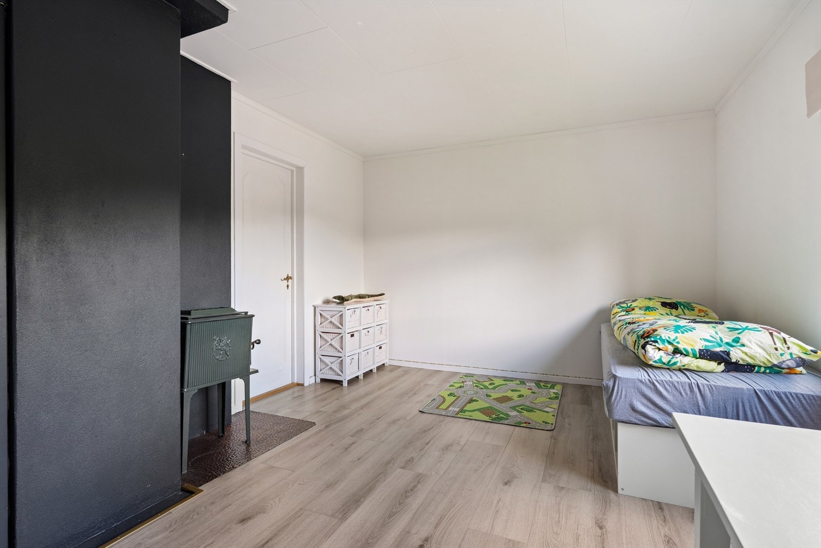 Soverom med god plass til seng og møblering, samt vedovn. Galleribilde