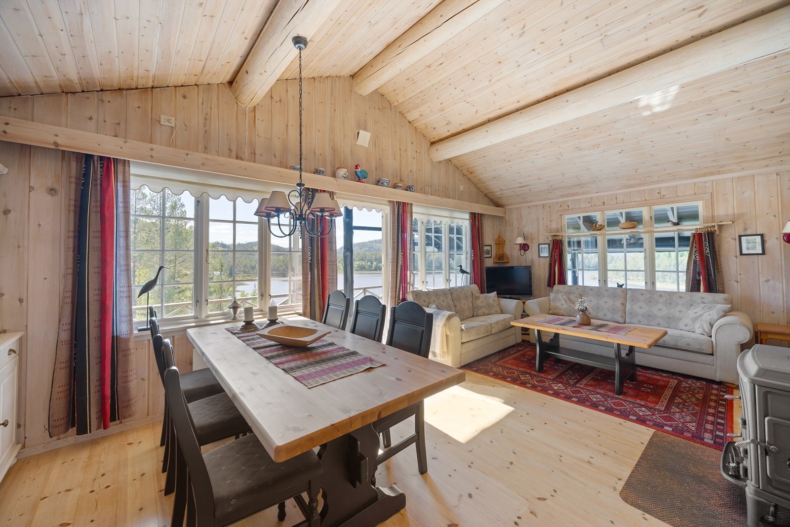 Stuen har plass til både spisebord og sofagruppe, med store vindusflater som slipper naturen inn. Galleribilde