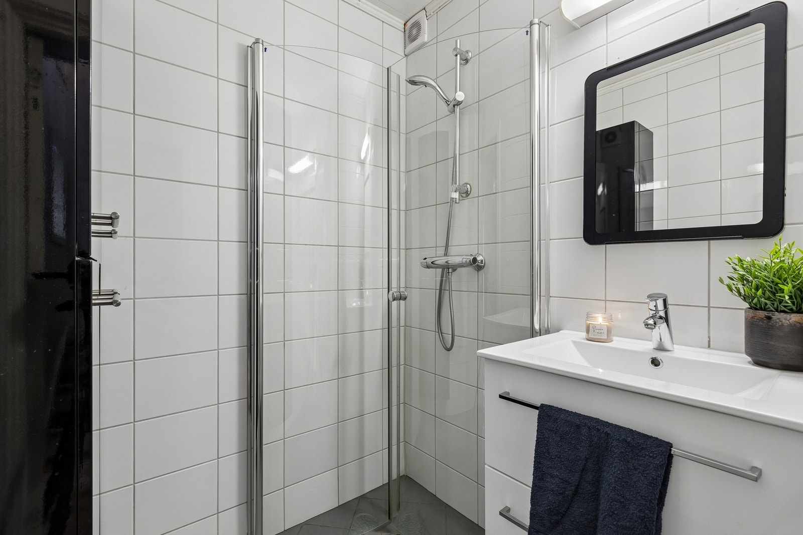 Pent flislagt baderom med tidløs stil og praktisk innredning. Galleribilde