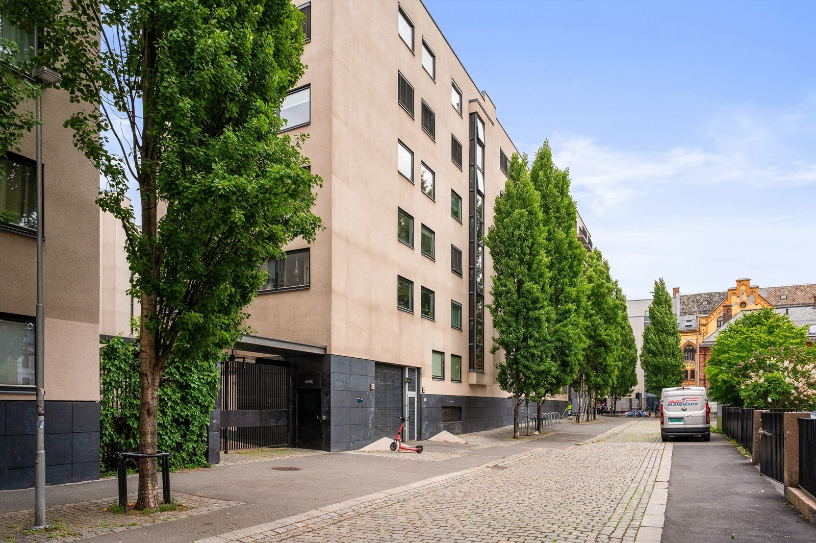 Jess Carlsens gate 6 har perfekt beliggenhet for den som ønsker å bo sentralt. Innkjøring til garasjeanlegg ved elsparkesykkelen. Boligen vender ut mot bakgården på andre siden. Galleribilde