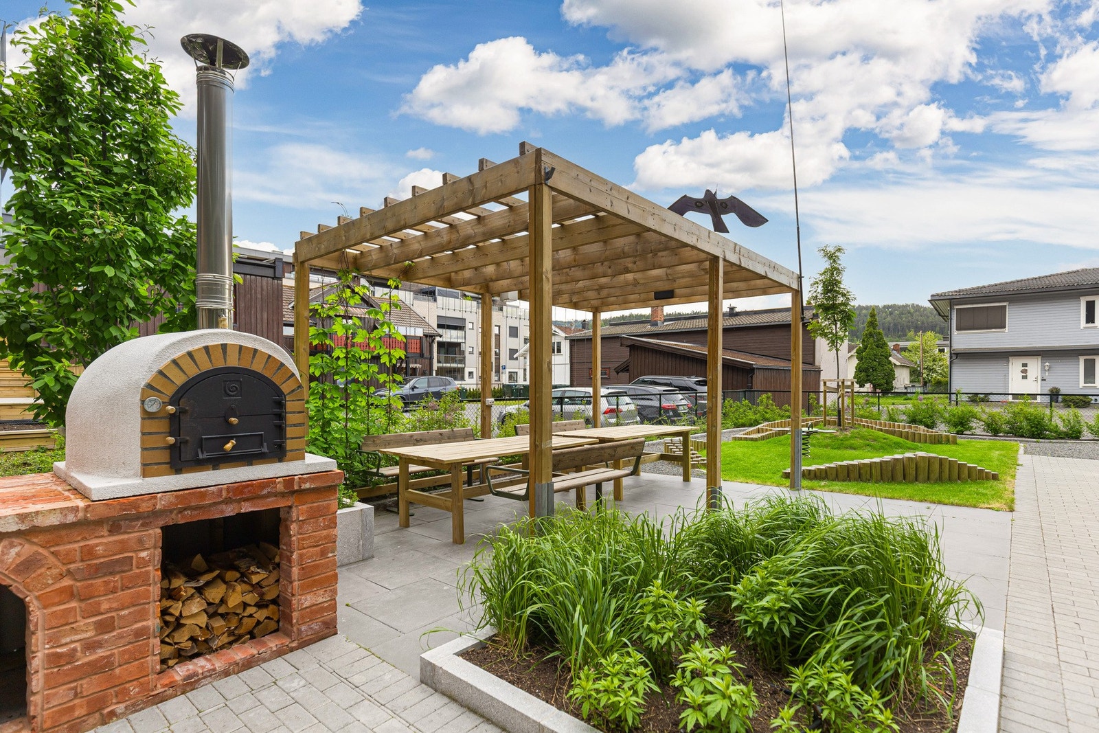 Her finner man også en sjarmerende pergola og flere soner med sittegrupper - perfekte for både avslapning og hyggelig samvær med naboer. Galleribilde