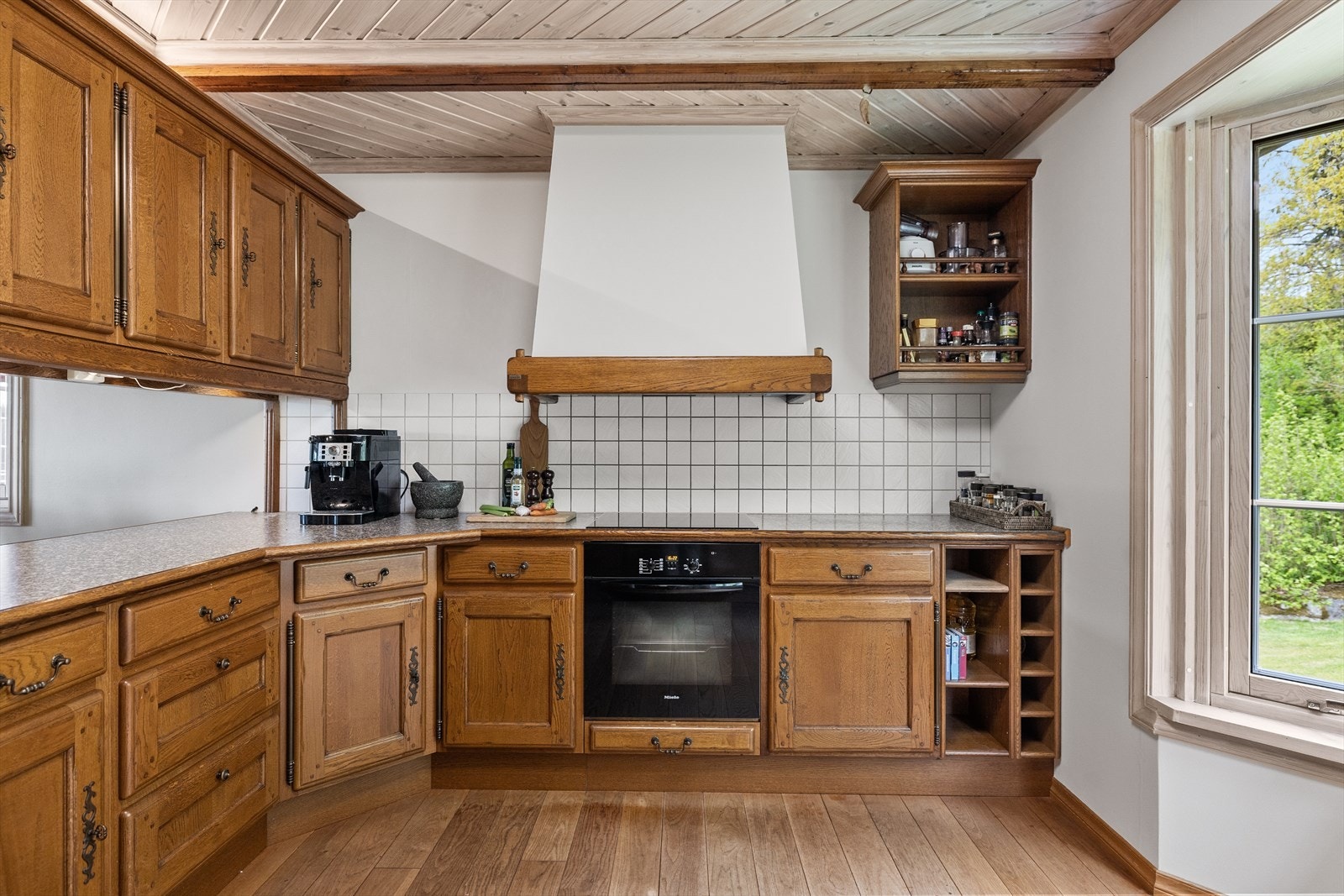 Kjøkkenet har en funksjonell og innholdsrik innredning med rikelig skap- og benkeplass, noe som gir gode arbeidsforhold og god oppbevaringskapasitet. Galleribilde