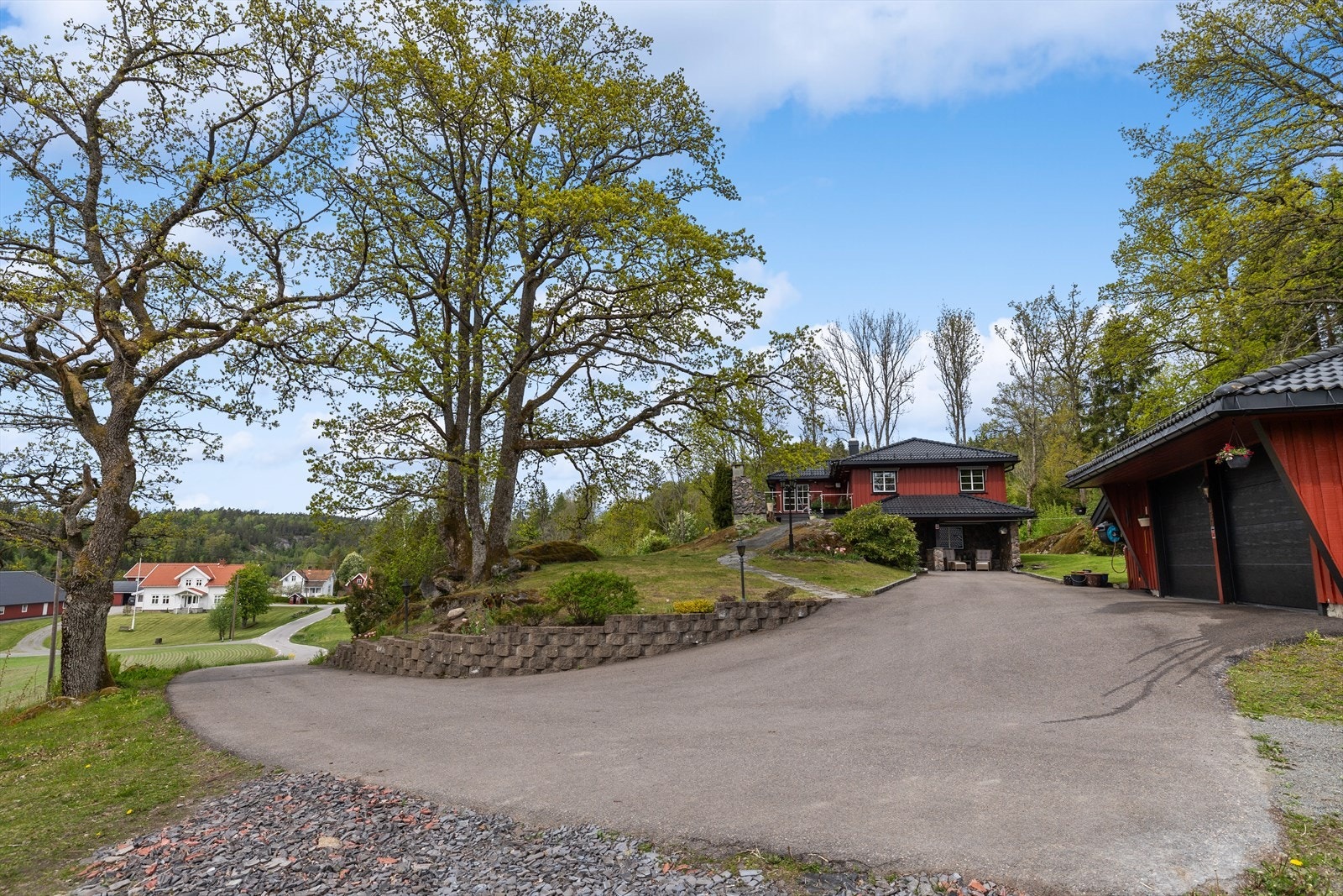 Eiendommen har en velstelt og innbydende innkjøring som gir et svært godt førsteinntrykk ved ankomst. Den pent opparbeidede adkomsten er både praktisk og representativ, med god plass til parkering og enkel tilkomst til boligen og garasjen. Galleribilde