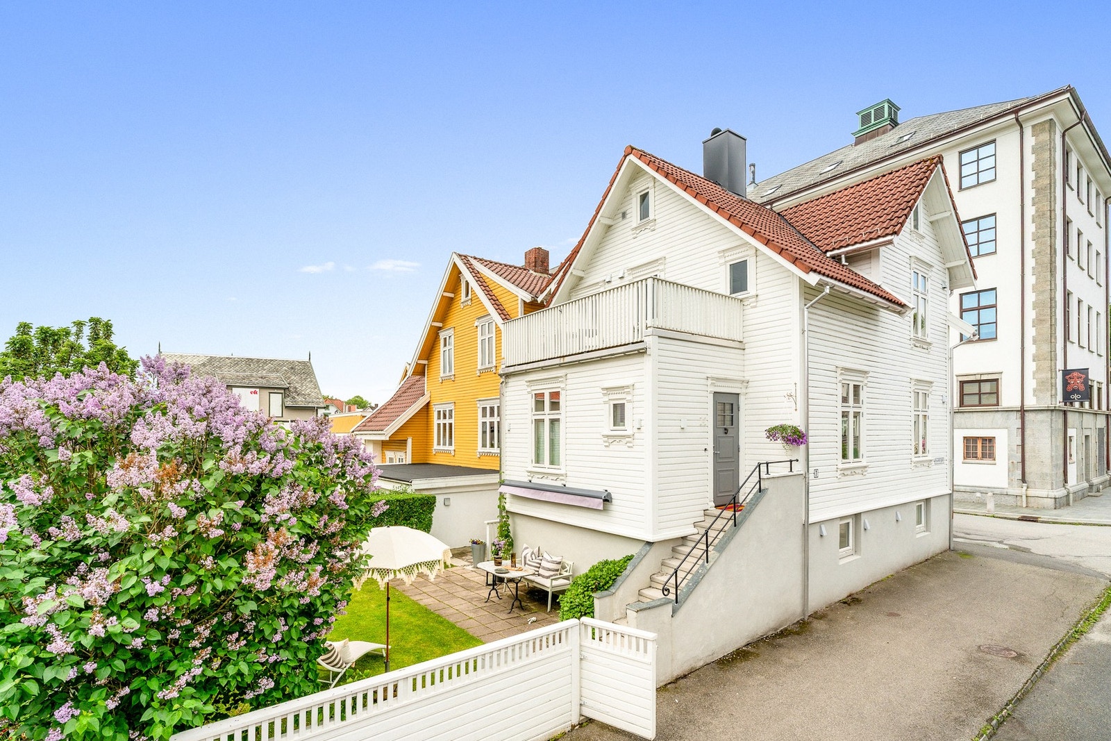 Den inngjerdede hagen er flat og solrik, med plen, variert beplantning og en stor hellelagt uteplass. Galleribilde