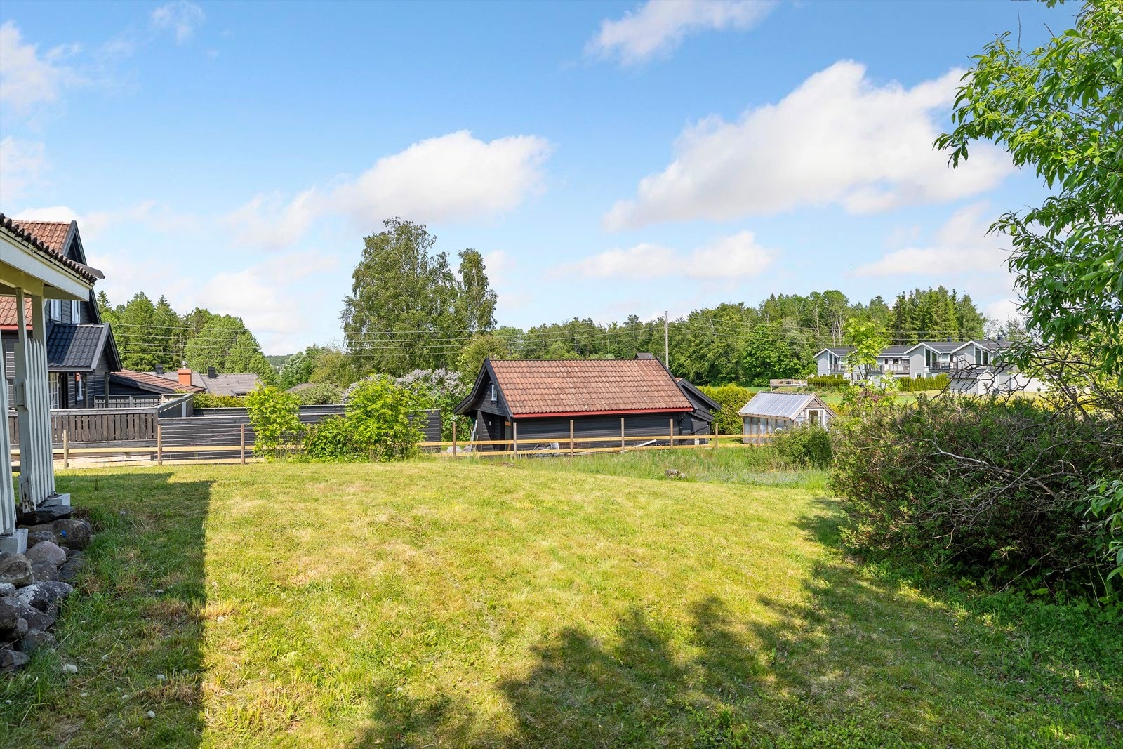 Tomten er beplantet med busker som bidrar til et grønt og innbydende uttrykk gjennom store deler av året. Her kan både barn og voksne nyte fine dager utendørs, enten det er til lek, hagearbeid eller avslapning i rolige omgivelser. Galleribilde