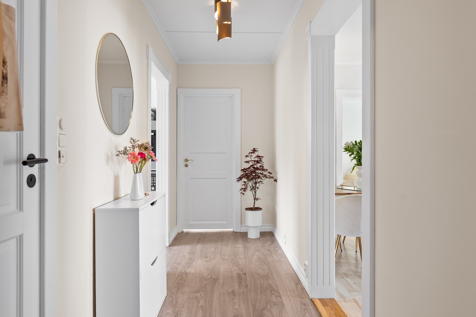Her ønskes du velkommen inn i en bolig med en trivelig atmosfære og gjennomgående gode overflater. Entréen har en praktisk utforming som gir plass til oppheng av yttertøy og oppbevaring av sko, samtidig som den oppleves ryddig og oversiktlig. Galleribilde