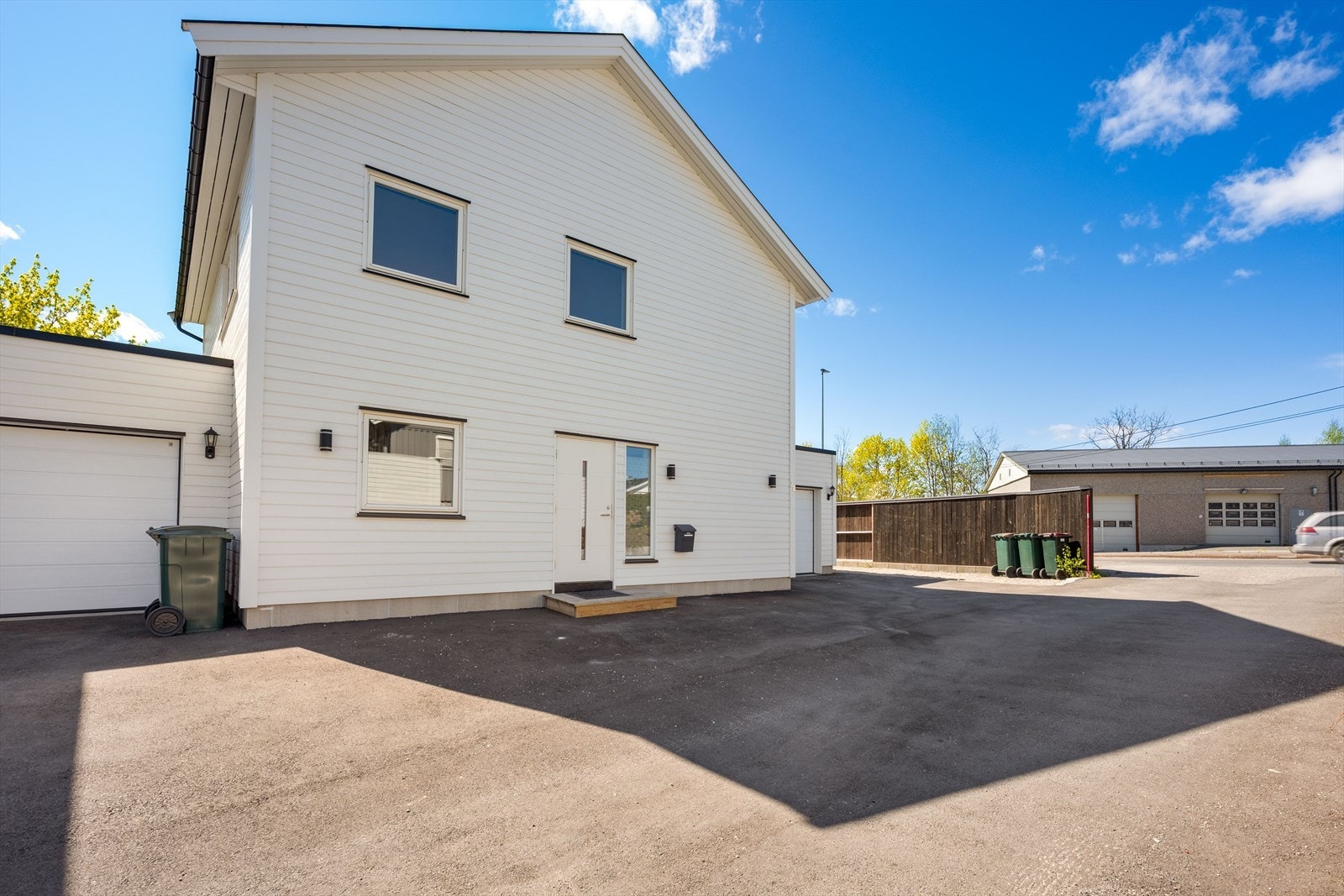 Asfaltert gårdsplass fører frem til inngangspartiet og den isolerte garasjen. Galleribilde