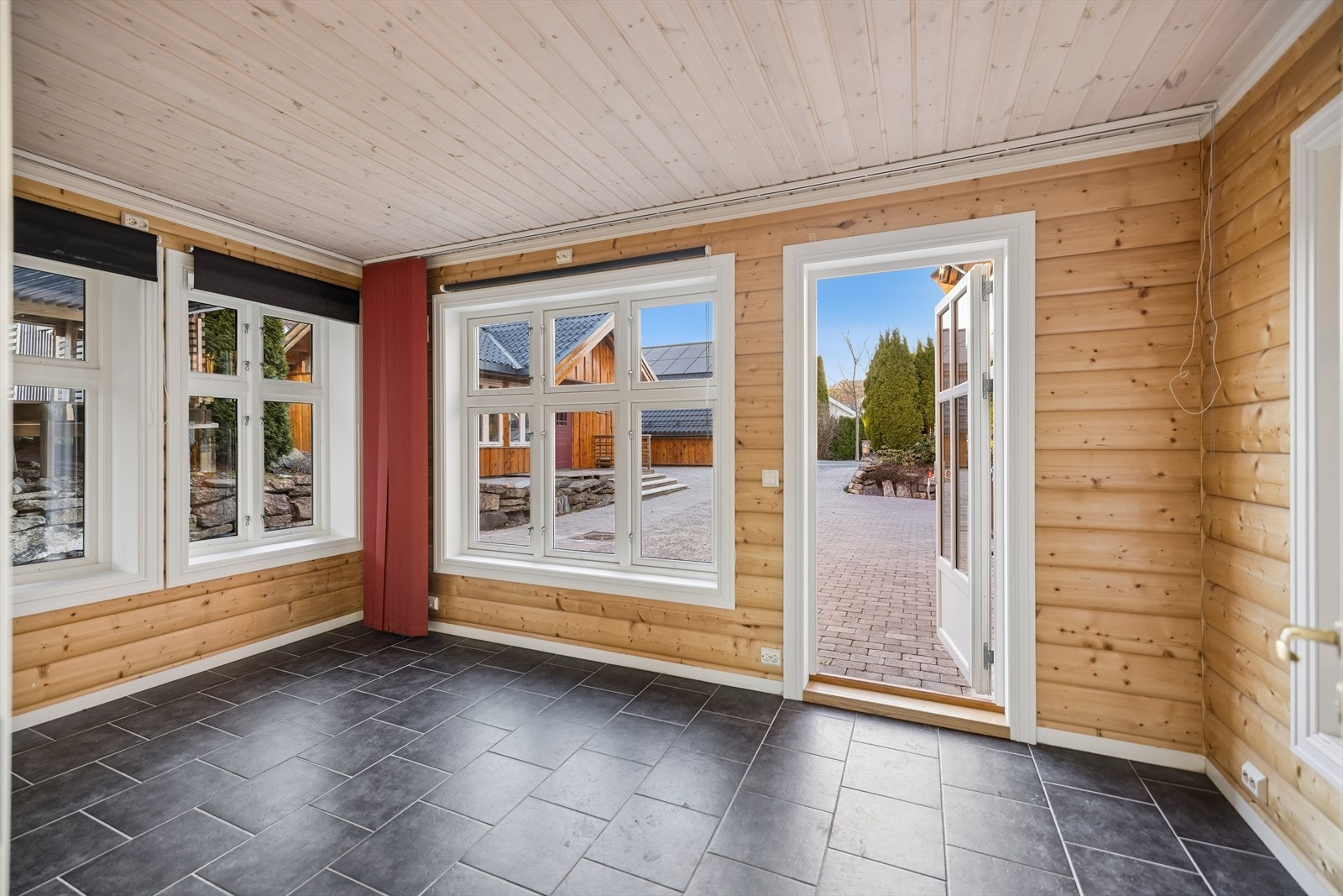 En av boligens vinterstuer, med flislagt gulv, gulvvarme og direkte utgang til gårdsplassen. Galleribilde