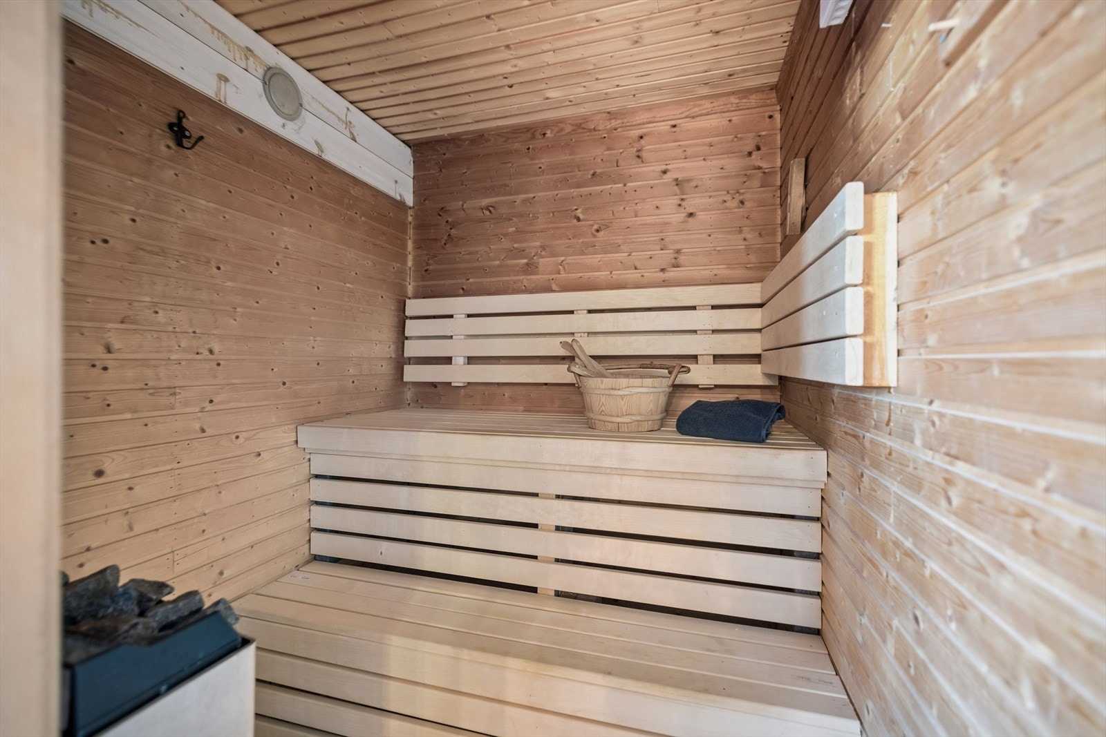 I tilknytning til badet ligger en badstue med panelte overflater og badstueovn fra Tylø. Galleribilde