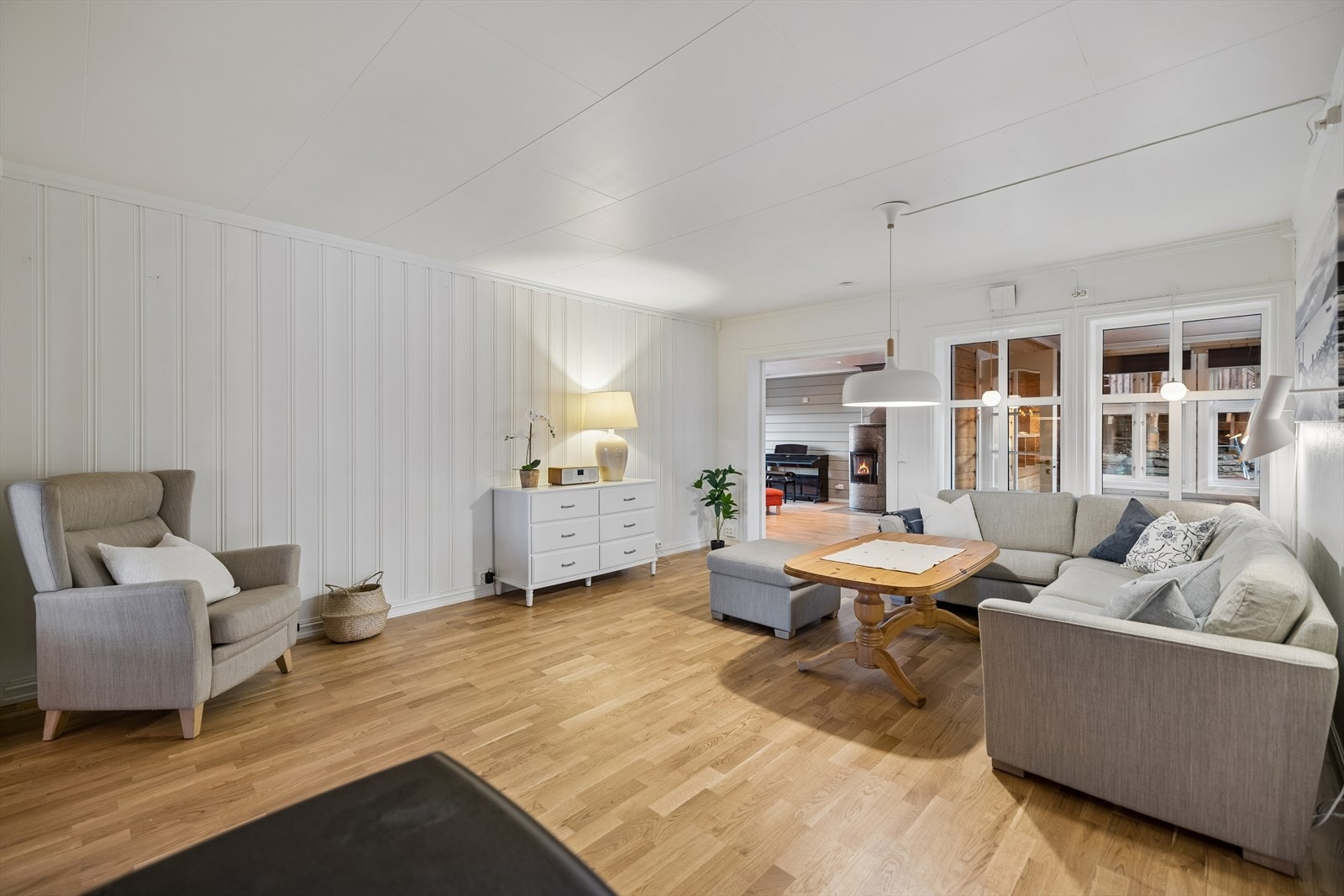 Fra stuen er det åpne overganger til spisestue og peisstue, noe som skaper en sosial og sammenhengende sone i boligens første etasje. Galleribilde