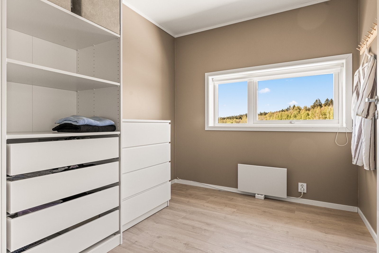 Et av de tre soverommene er i dag brukt om garderobe, men her er det god plass til seng og øvrig møblement. Galleribilde