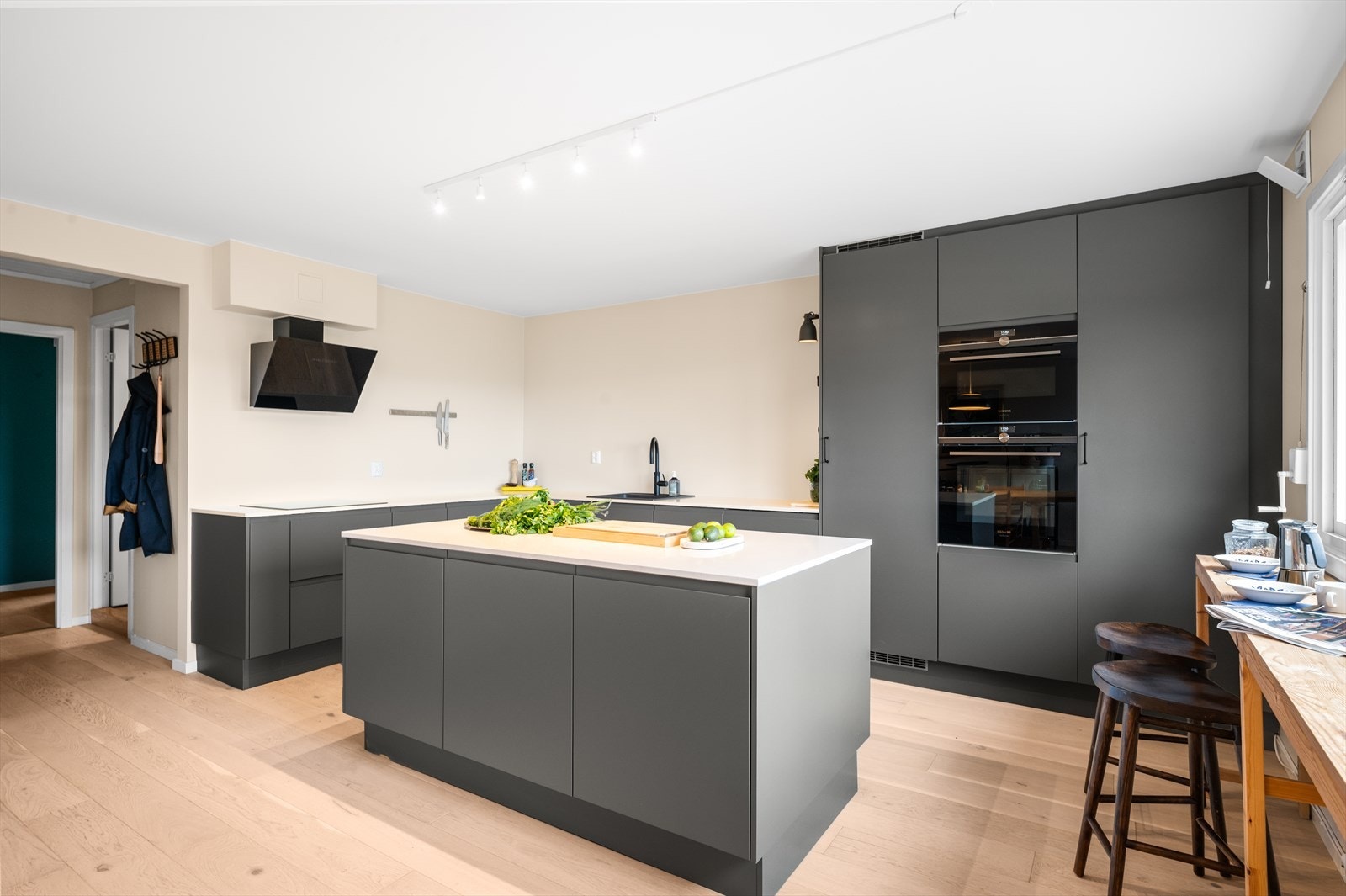 Kjøkkeninnredning fra HTH (2019) med glatte fronter og en sosial kjøkkenøy. Integrert oppvaskmaskin og induksjonstopp (Electrolux), samt kombinert mikro-/stekeovn, damp -/stekeovn og kjøleskap i full tørrelse (Siemens). Galleribilde