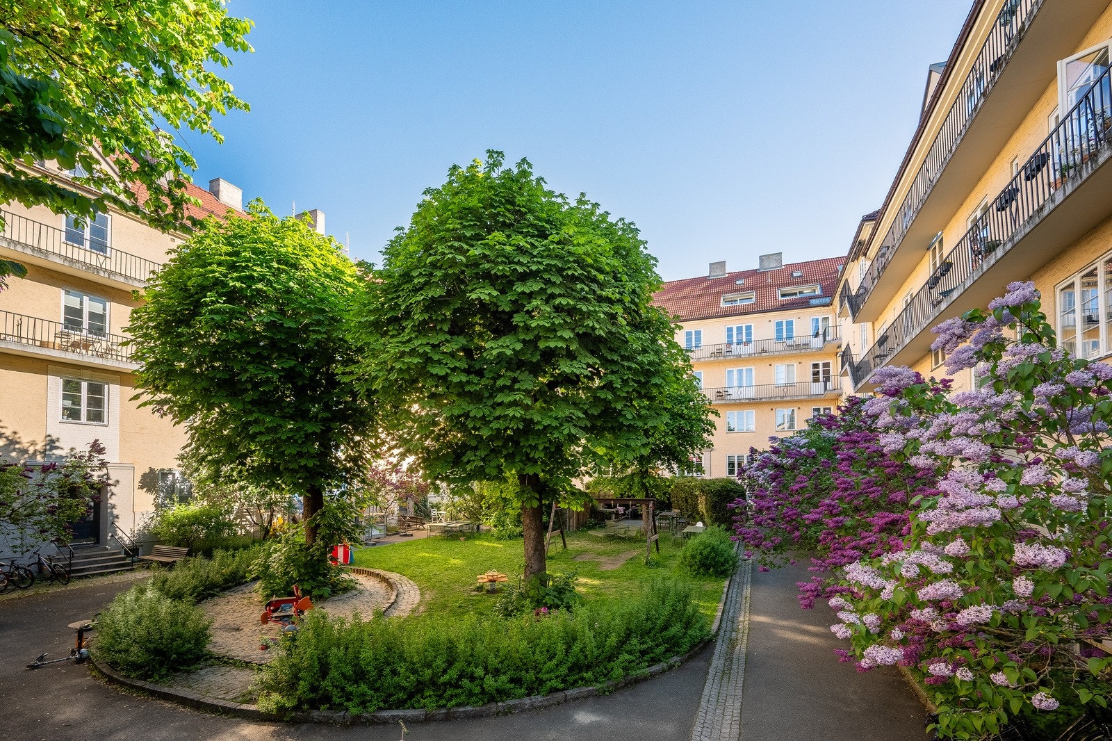 Midt i det urbane finner man en frodig bakgård, hvor grønne omgivelser skaper ro og balanse Galleribilde
