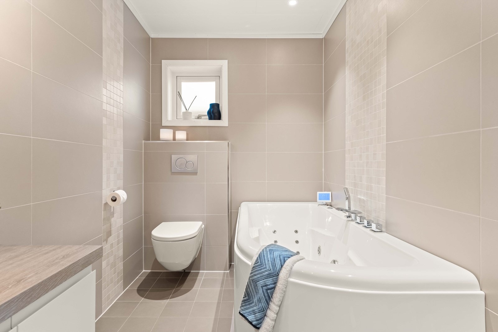 Badet er helfliset og har vegghengt toalett med innebygget sisterne. Galleribilde