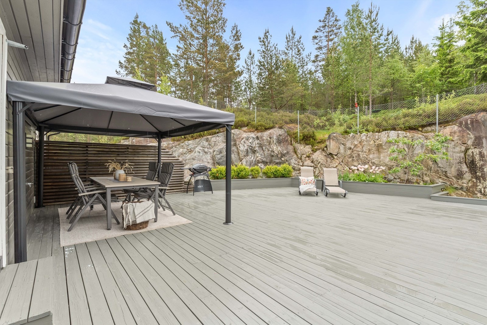 Terrassen er bygget i tre og rammer inn uteområdet mot fjellet i bakkant. Galleribilde