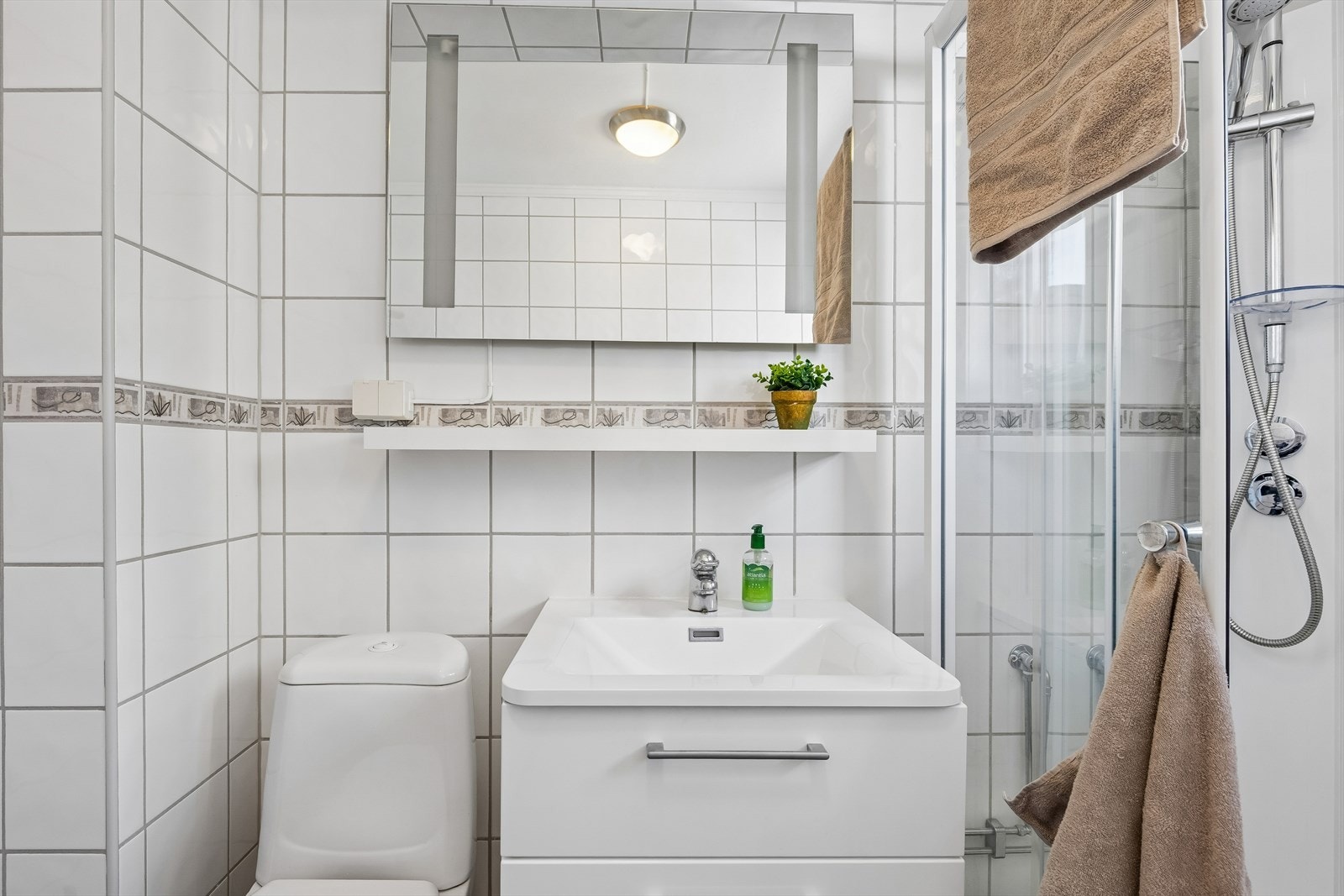 Innredningen består av servantmøbel, speil og en praktisk hylle. Galleribilde