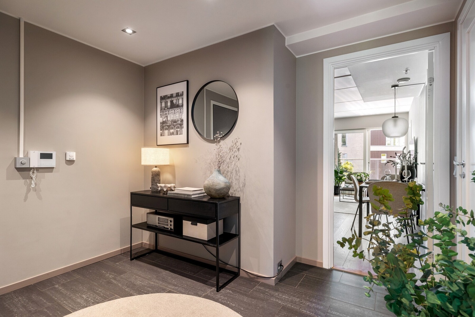Entréen er innbydende med downlights og dørcalling. På gulvet er det lagt praktiske fliser med vannbåren varme som tørker effektivt opp etter våte klær og sko Galleribilde