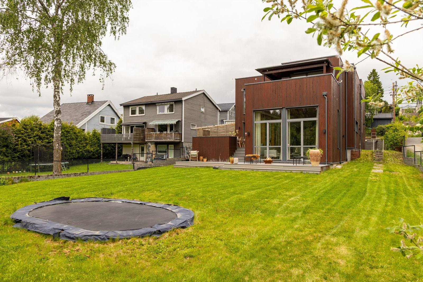 I forkant av boligen finner du en stor og lettstelt hage med gode solforhold og rikelig med plass til lek, aktivitet og hyggelige sammenkomster. Den nedfelte trampolinen følger med salget. Galleribilde