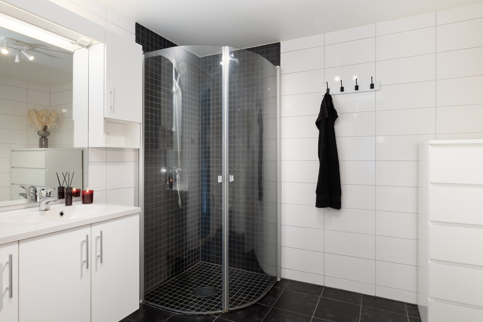 Flott heilflisa bad med varme i golv og servant med kvit skåpseksjon. Galleribilde
