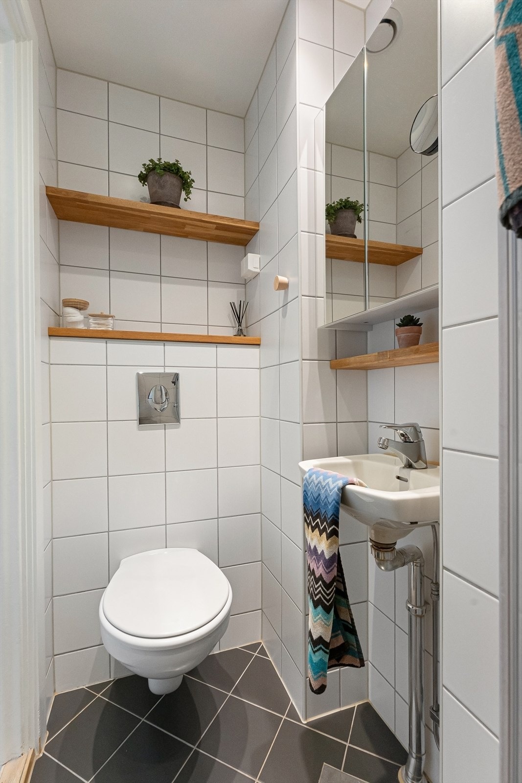 Badet er innredet med vegghengt toalett, servant og speilskap. Galleribilde