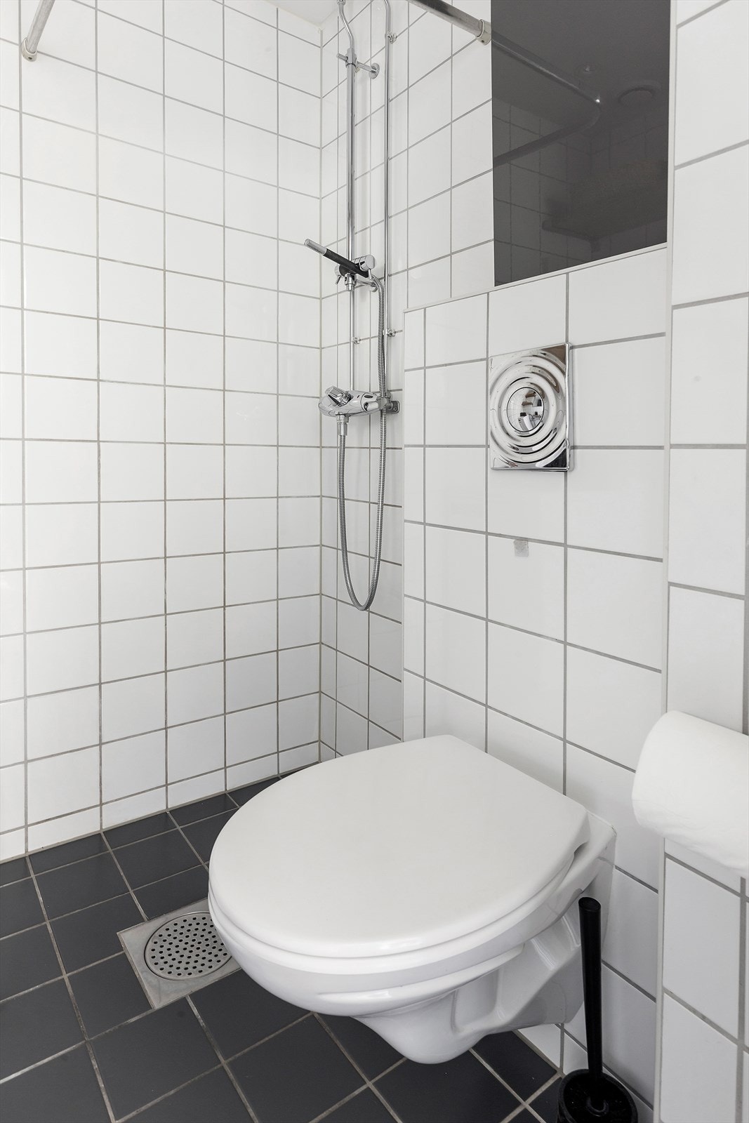 Badet er utstyrt med veggmontert toalett og plassbesparende dusjløsning Galleribilde
