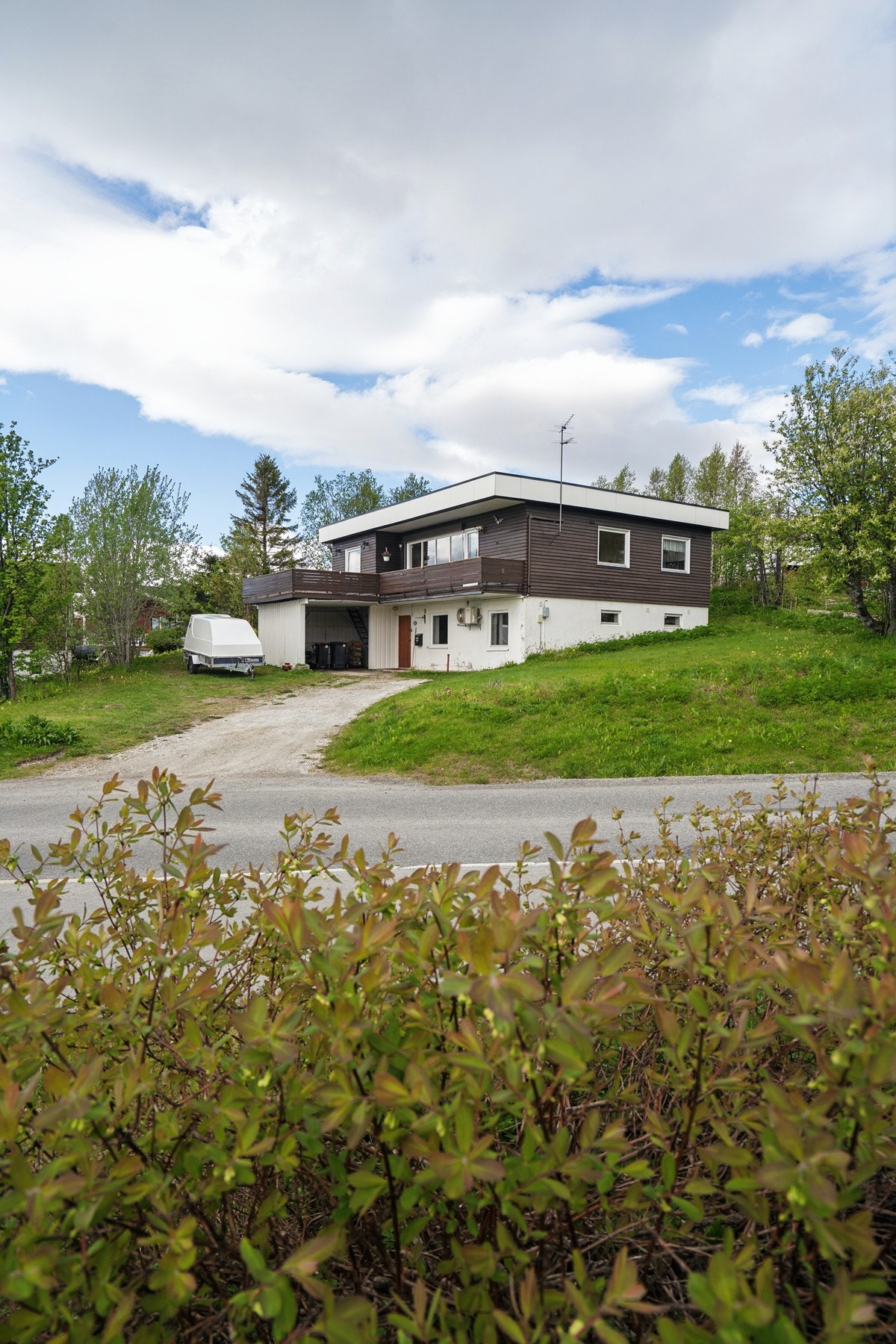 Carport oppført i trekonstruksjon ved siden av boligen. Galleribilde