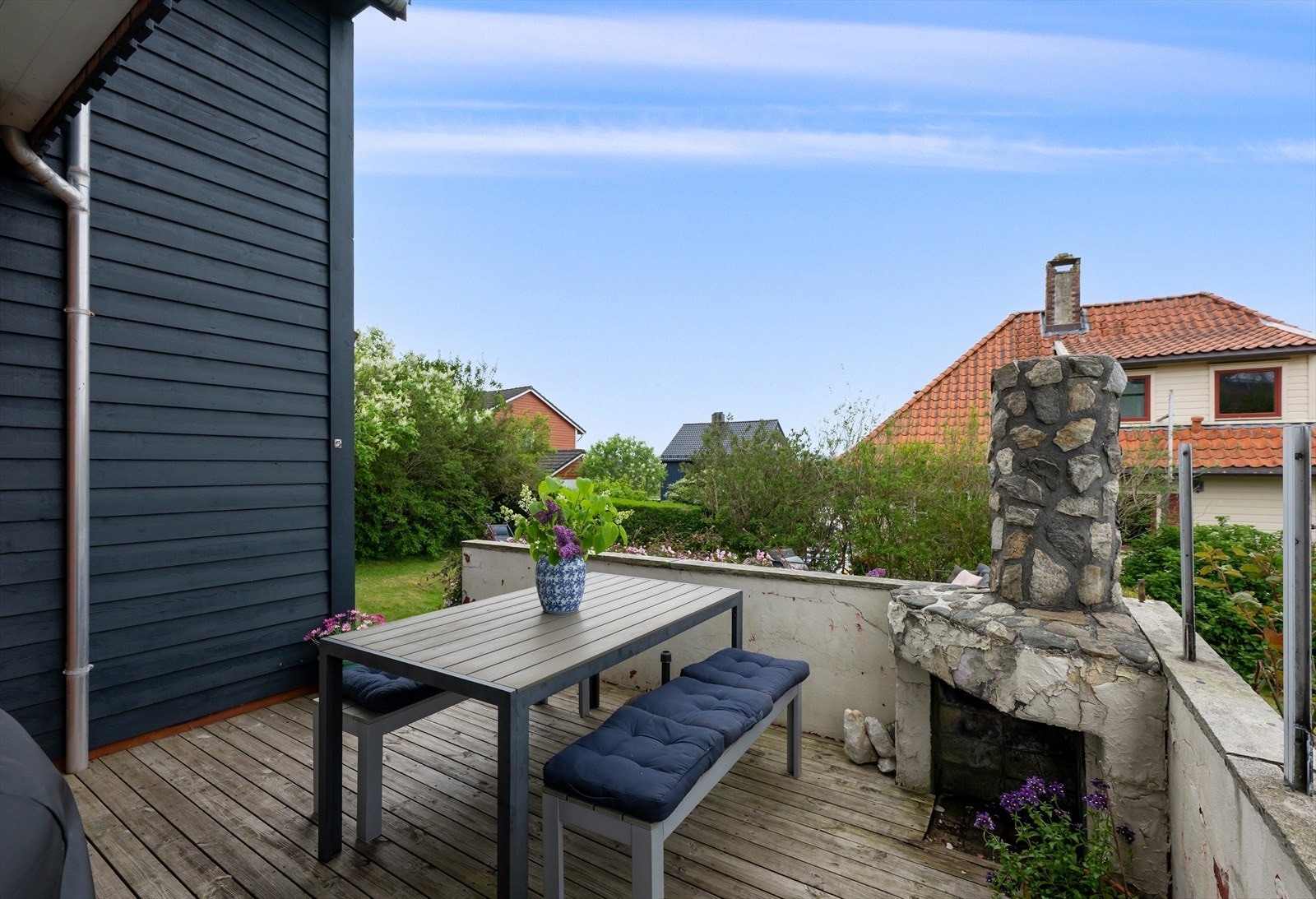 Uteplass med tregulv og en eldre utegrill. Galleribilde