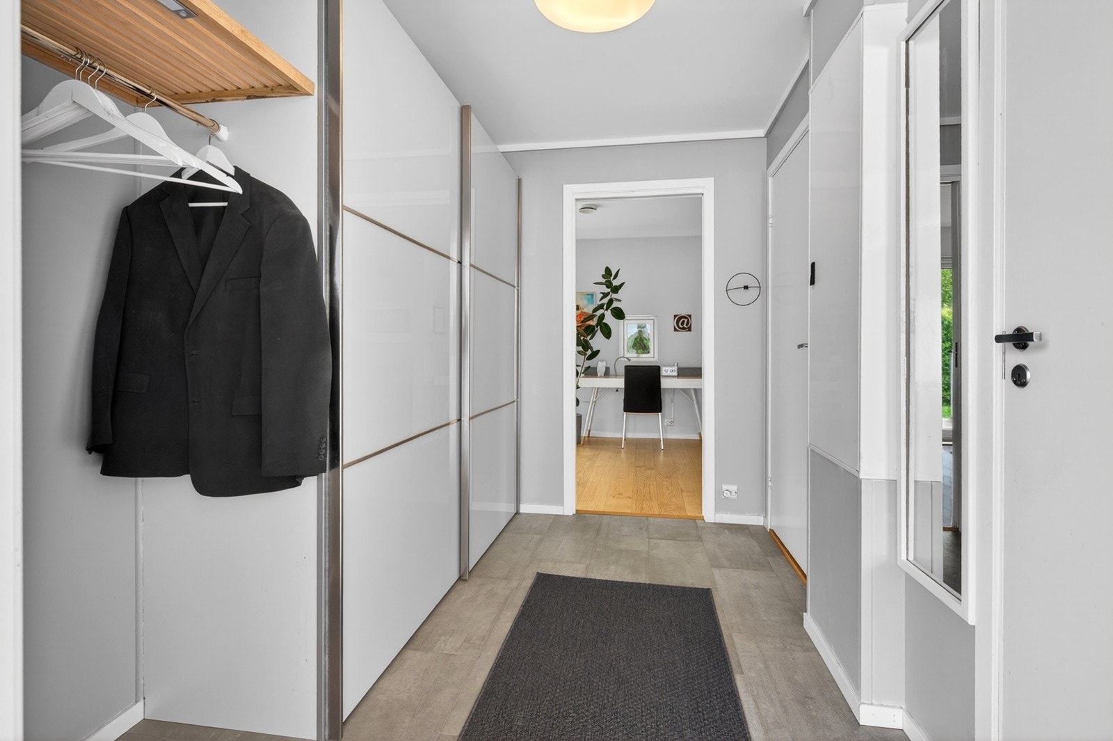 Hyggelig entré med romslig skyvedørsgarderobe Galleribilde