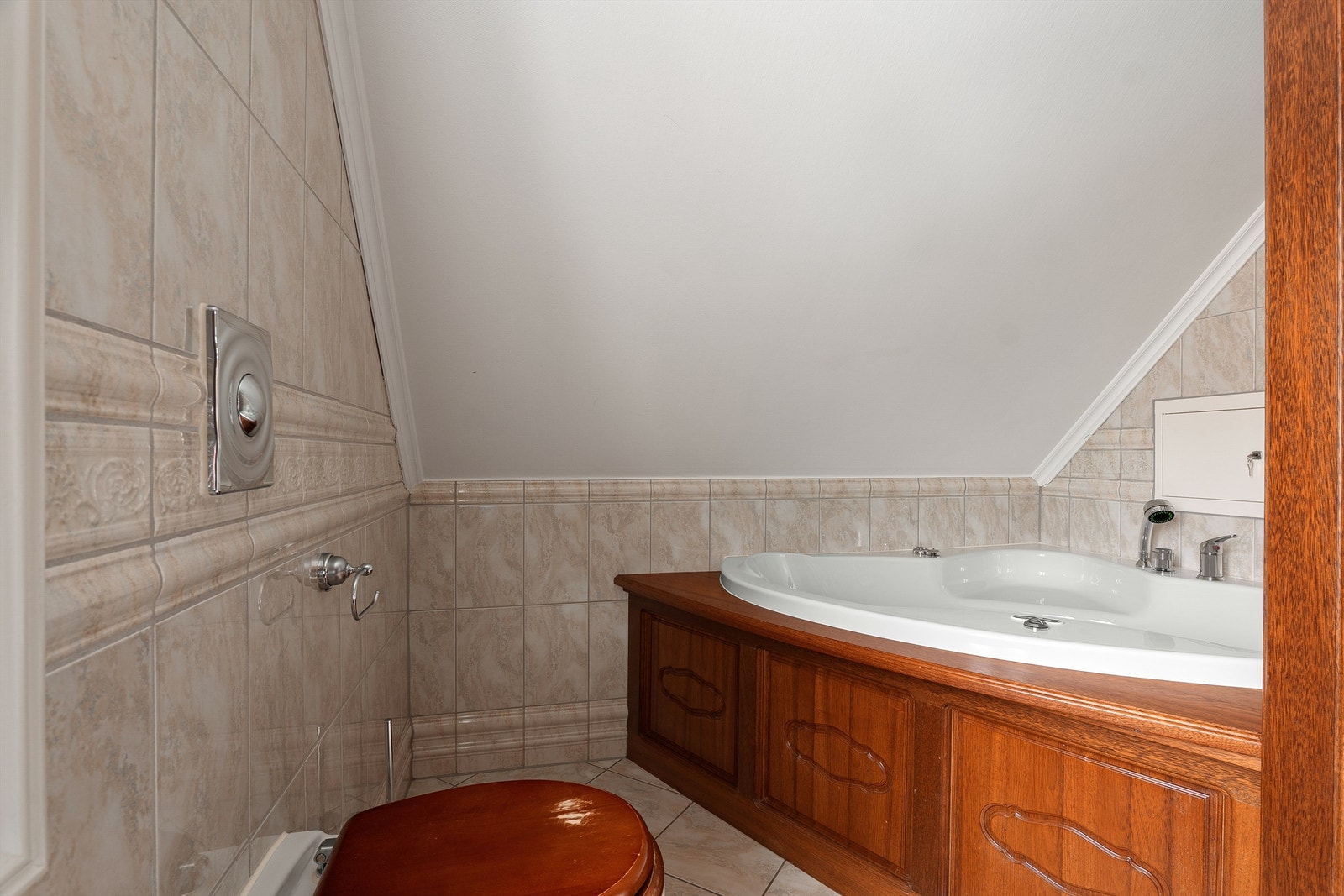 Badet inneholder både dusjkabinett og innbygget badekar, med dekorativ utsmykning. Begge gir lite vannpåkjenning på gulv og vegger. Galleribilde