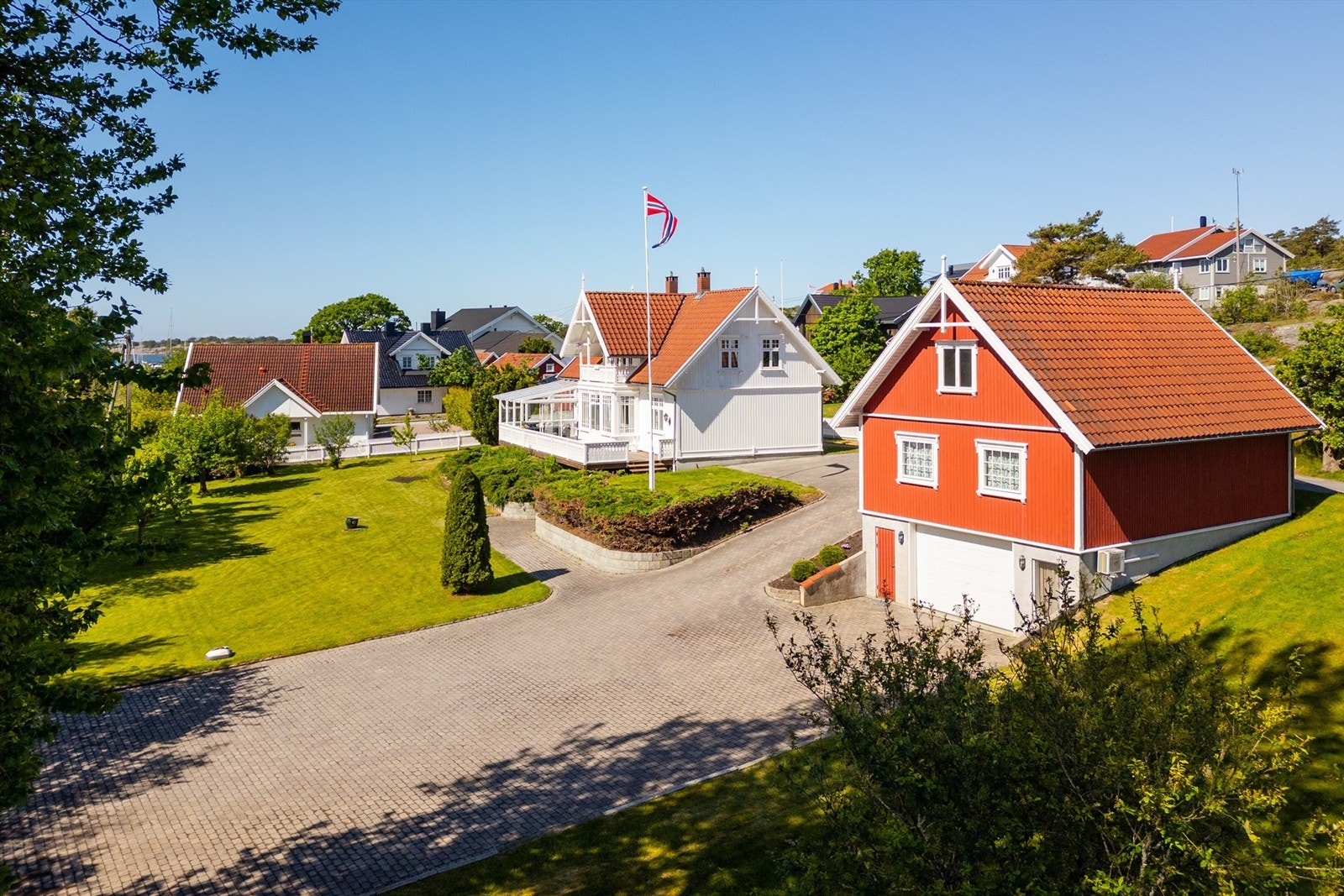Den store gårdsplassen nedenfor garasjen kan fint utnyttes til eksempelvis vinteropplag av egen båt. Garasjens kjeller nyttes i dag til verksted og lager. Galleribilde