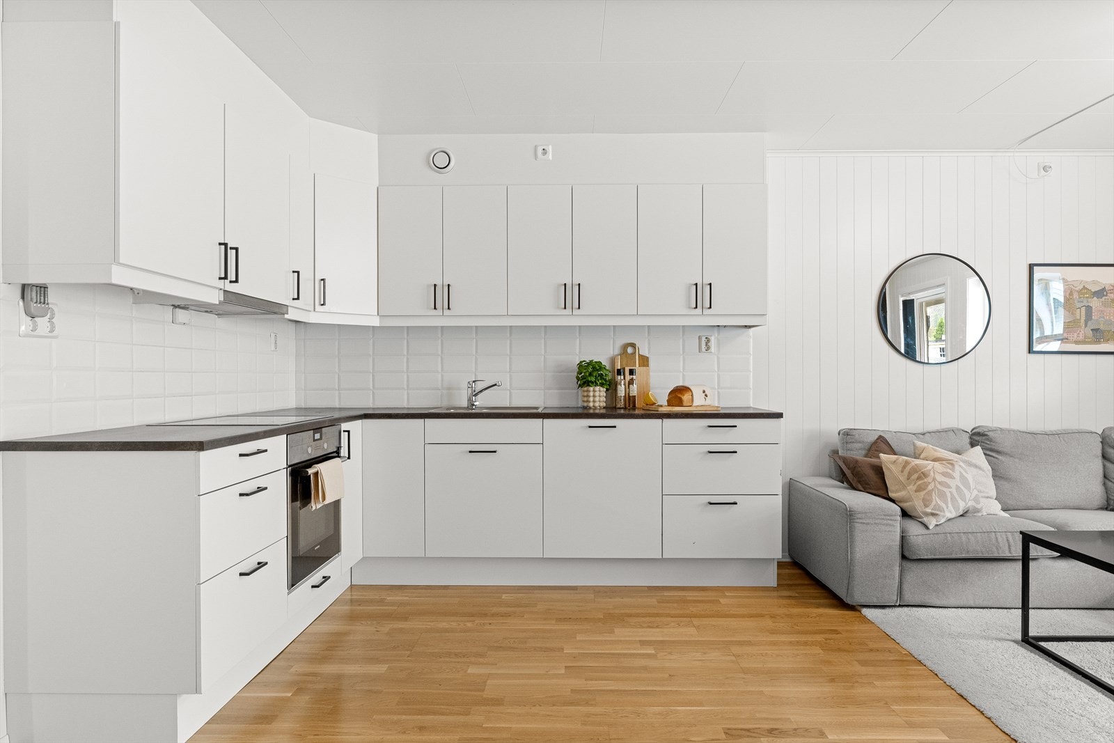 Kjøkkenet har glatte fronter med sorte håndtak. På kjøkkenet er det steikovn med platetopp, laminat benkeplate og nedfelt stålvask. Galleribilde