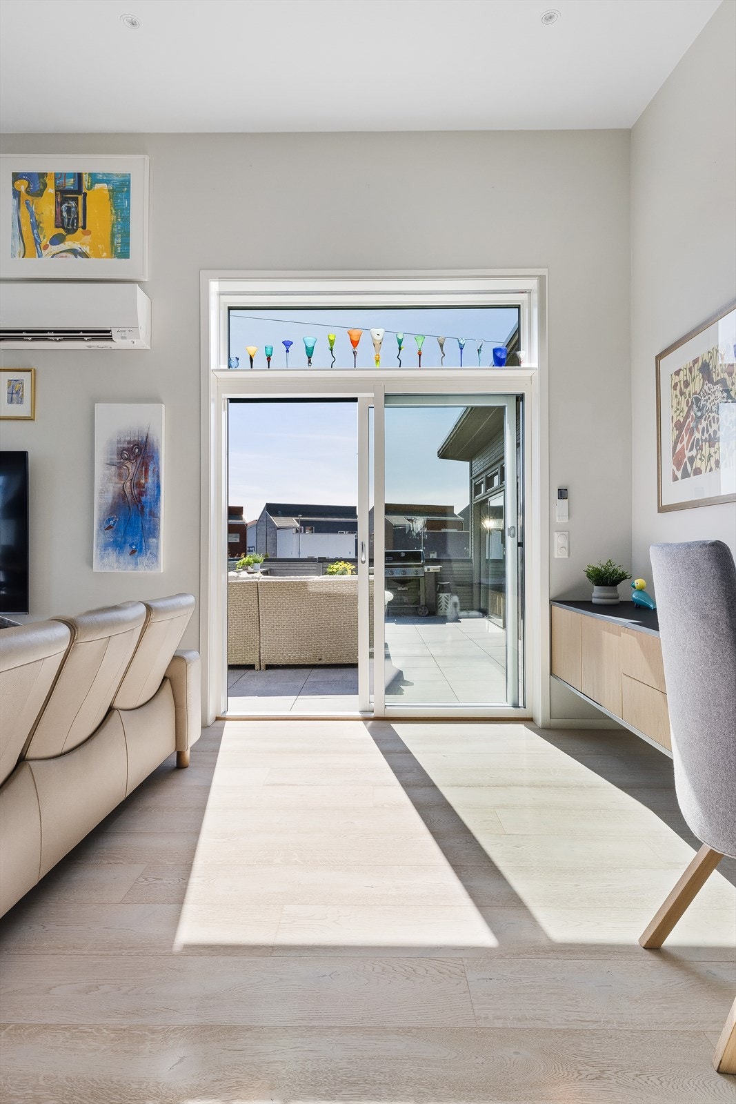 Store glassflater og utgang til uteplassen gir en lys og luftig atmosfære. Galleribilde