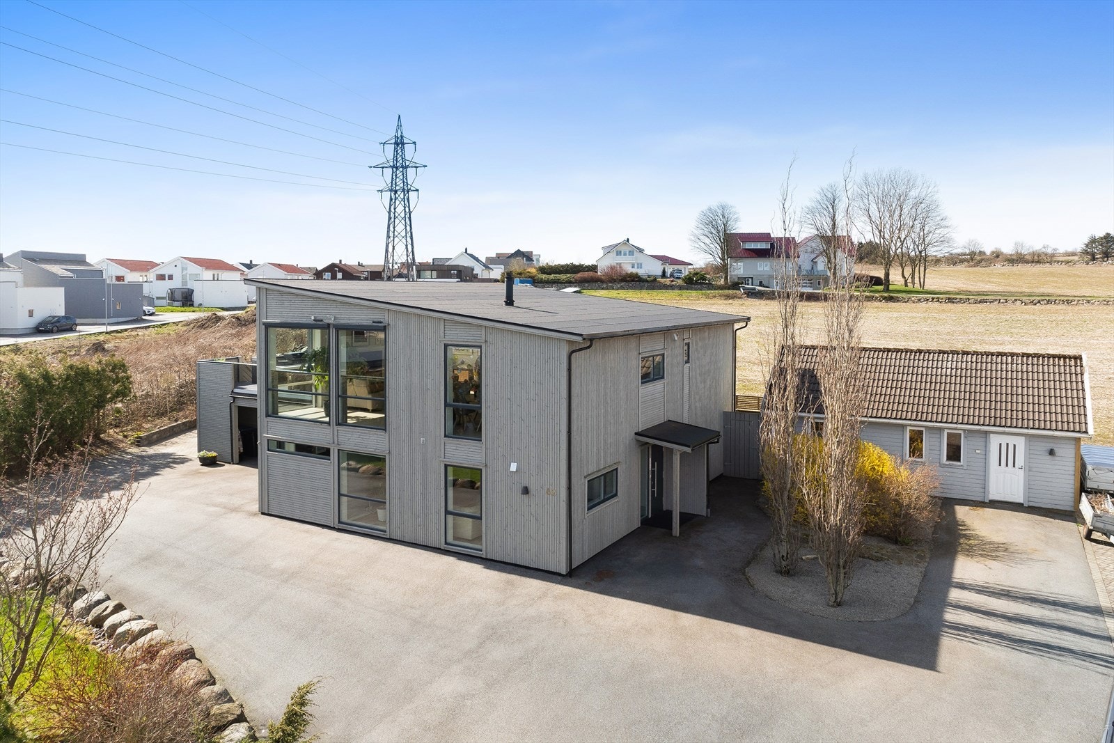 Moderne arkitektur med stående bordkledning og store vindusflater. Galleribilde