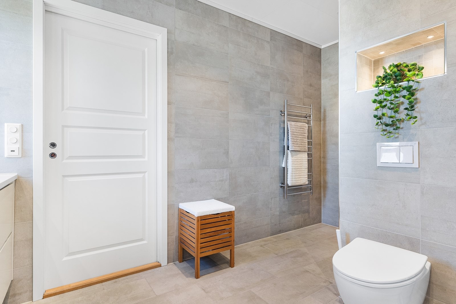 Badet har veggmontert toalett og balansert ventilasjon. Galleribilde