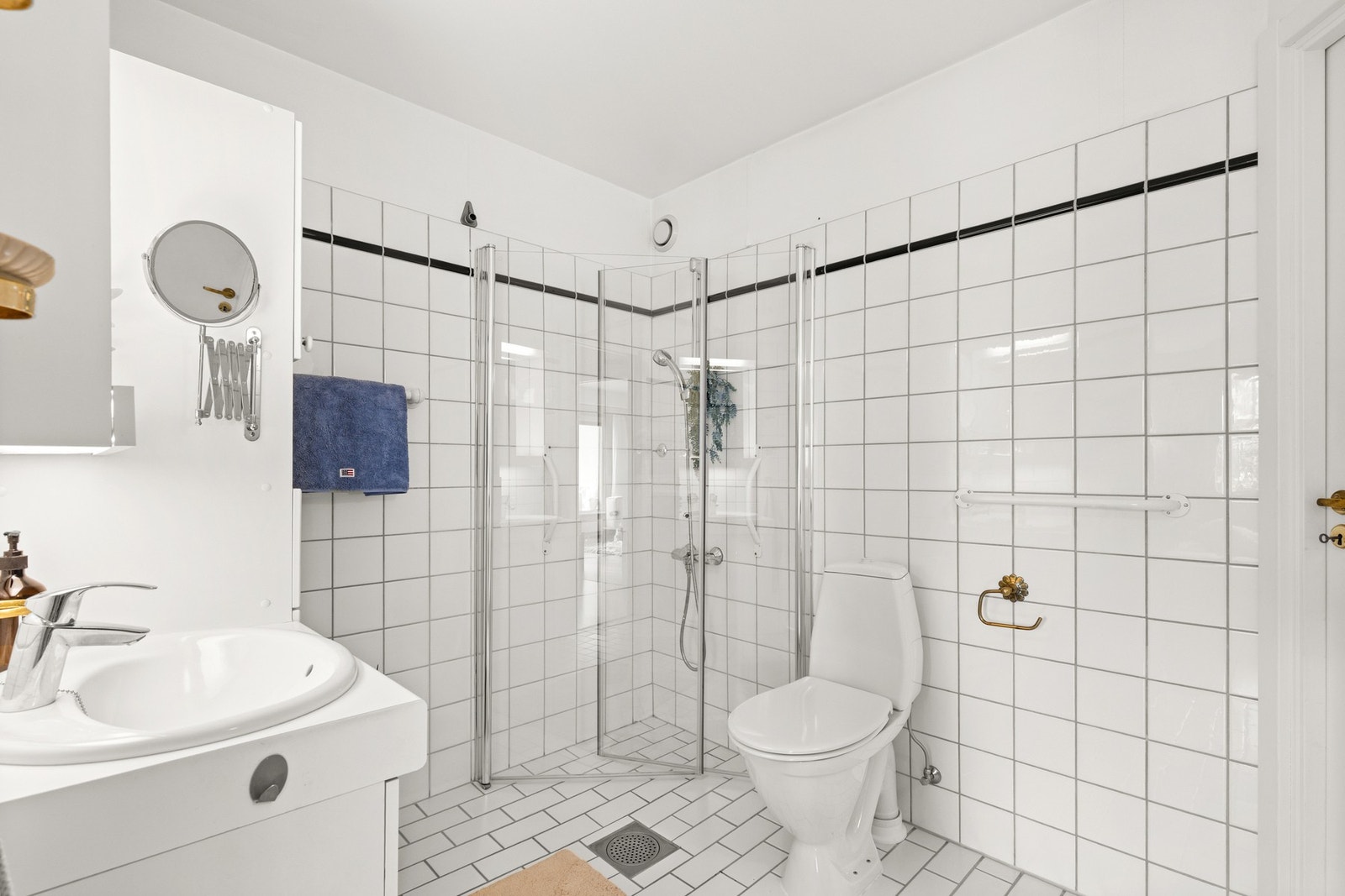 Badet er utstyrt med et romslig dusjhjørne med glassdører og termostatbatteri Galleribilde