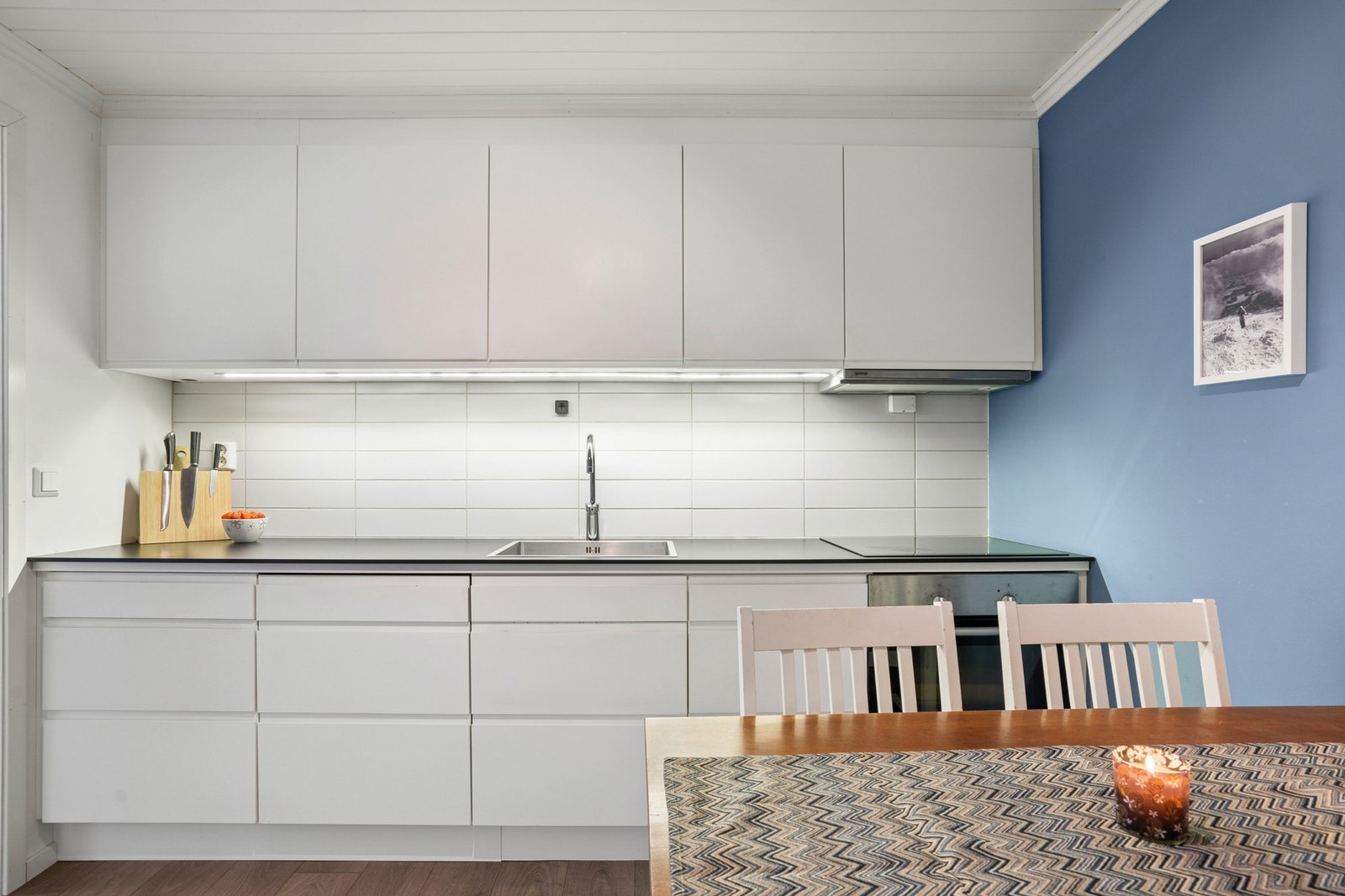 Moderne og lys kjøkkeninnredning med takhøye overskap. Galleribilde
