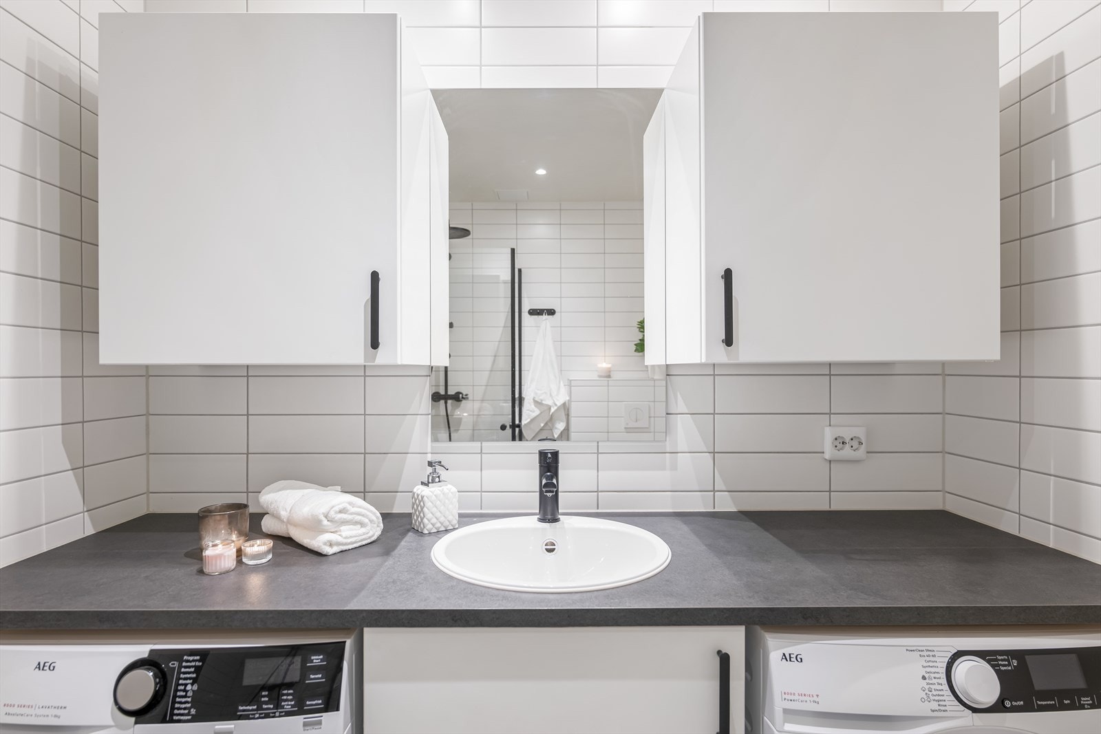 Baderomsinnredning med laminat arbeidsbenk, nedfelt servant og god oppbevaringsplass i under- og overskap. Galleribilde
