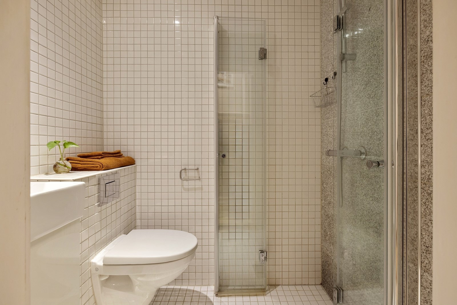 Badet er utstyrt med vegghengt toalett med innebygget sisterne. Galleribilde