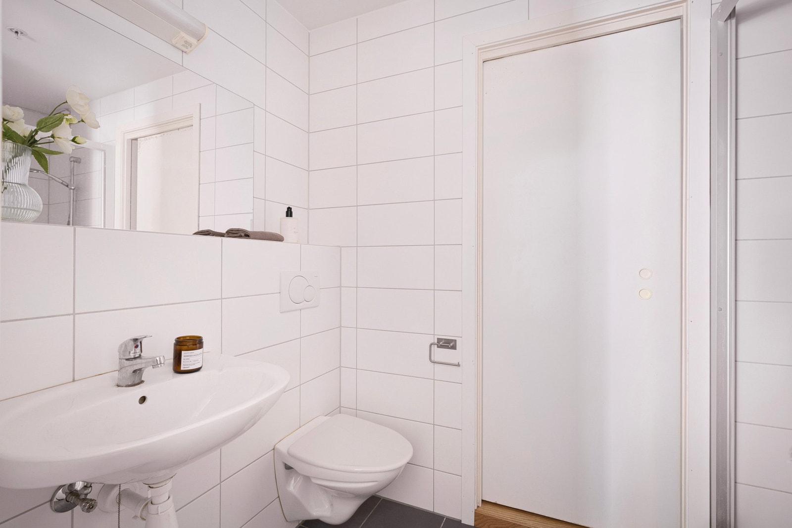 Badet er flislagt på vegger og gulv og har en lys, funksjonell innredning Galleribilde