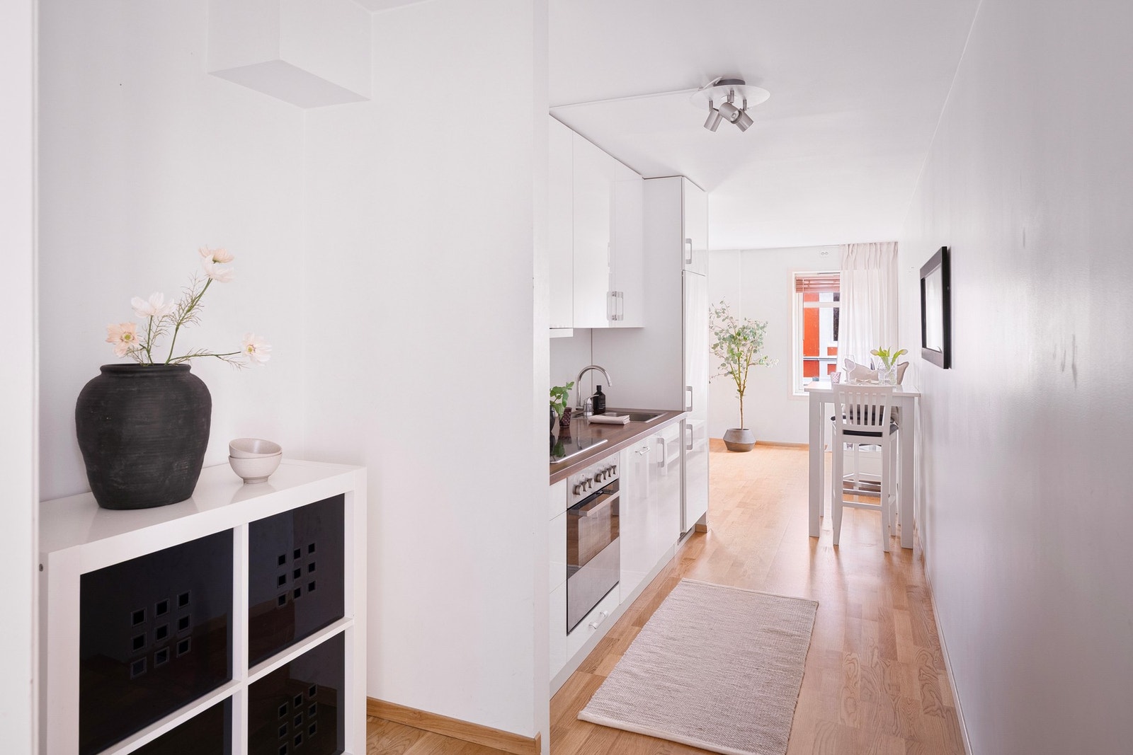 Innredningen har slette, hvite fronter, laminert benkeplate i trestruktur og nedfelt oppvaskkum. Galleribilde