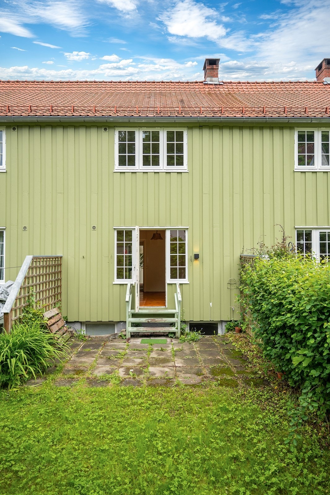 Fasaden har stående, malt trepanel, og taket er tekket med takstein. Galleribilde