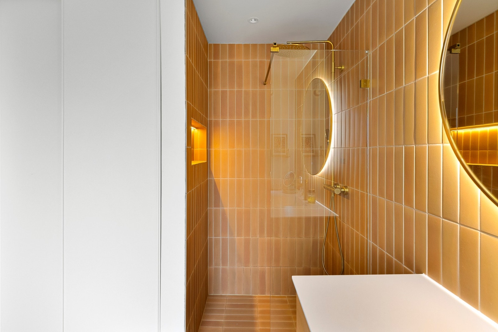 Badet er også praktisk tilrettelagt med opplegg for både vaskemaskin og tørketrommel, elegant skjult bak skyvedører i spesialtilpasset innredning. Galleribilde