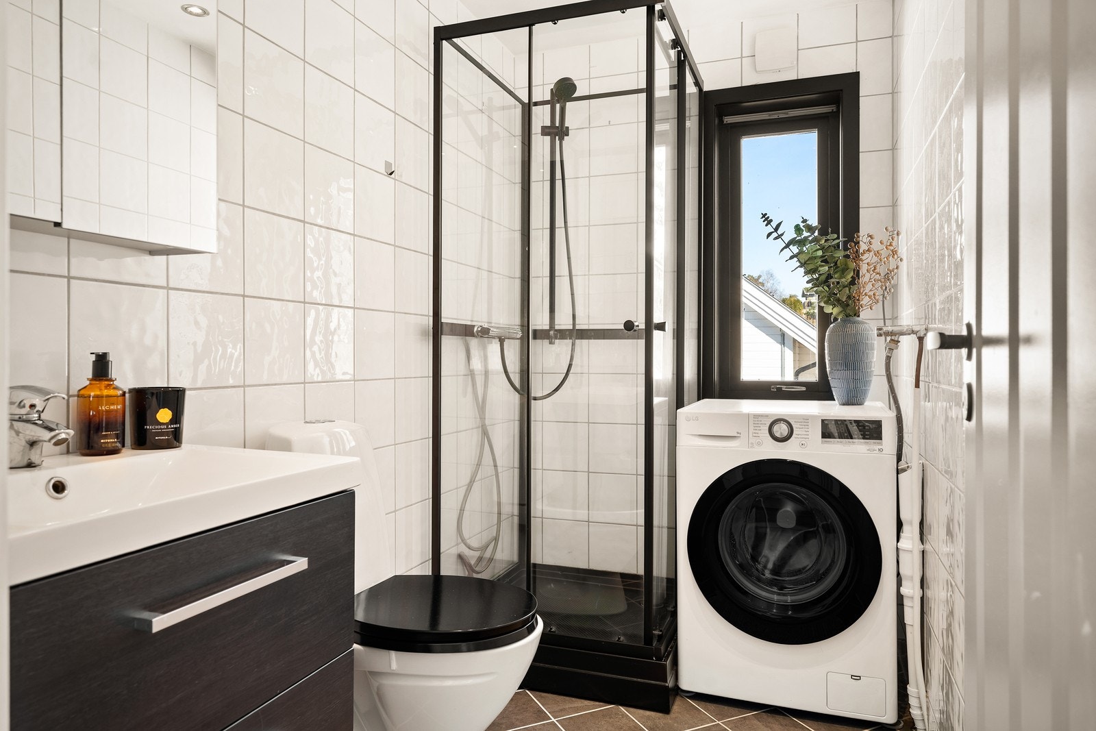 Badet i første etasje er praktisk innredet med dusjkabinett, opplegg for vaskemaskin og elektriske varmekabler i gulvet. Galleribilde