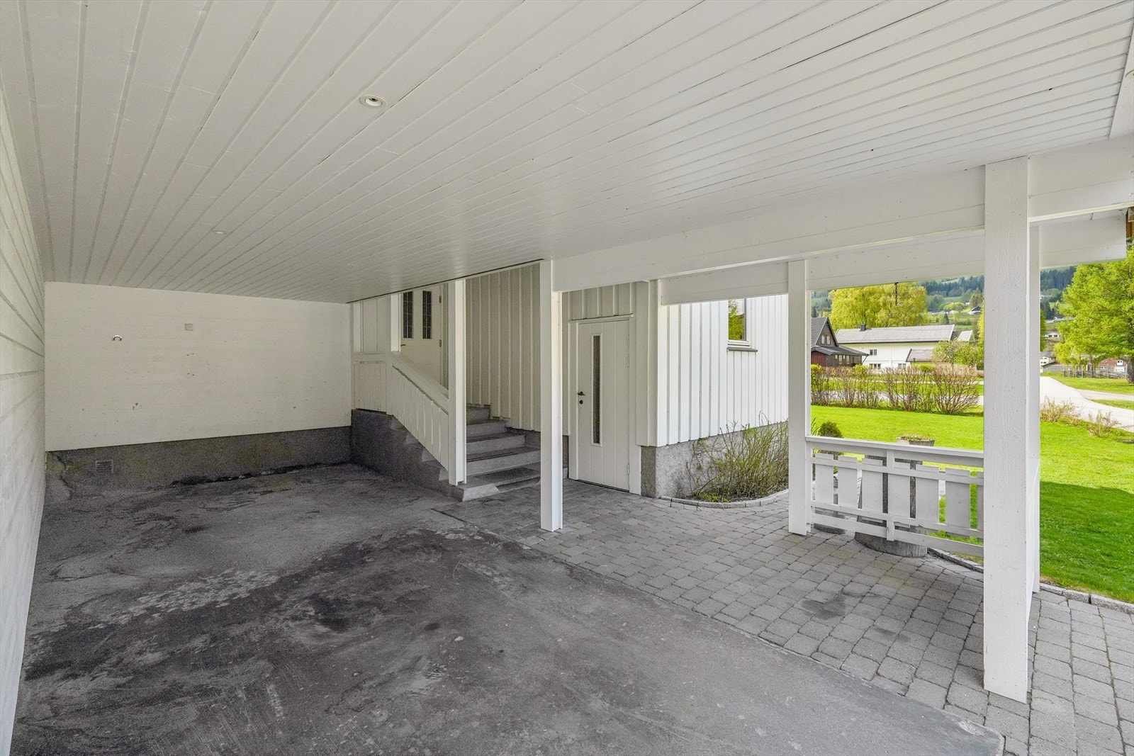 Boligen har tilhørende garasje og carport integrert med inngangspartiet, samt brosteinsbelagte parkeringsarealer som gir et pent og helhetlig førsteinntrykk. Galleribilde