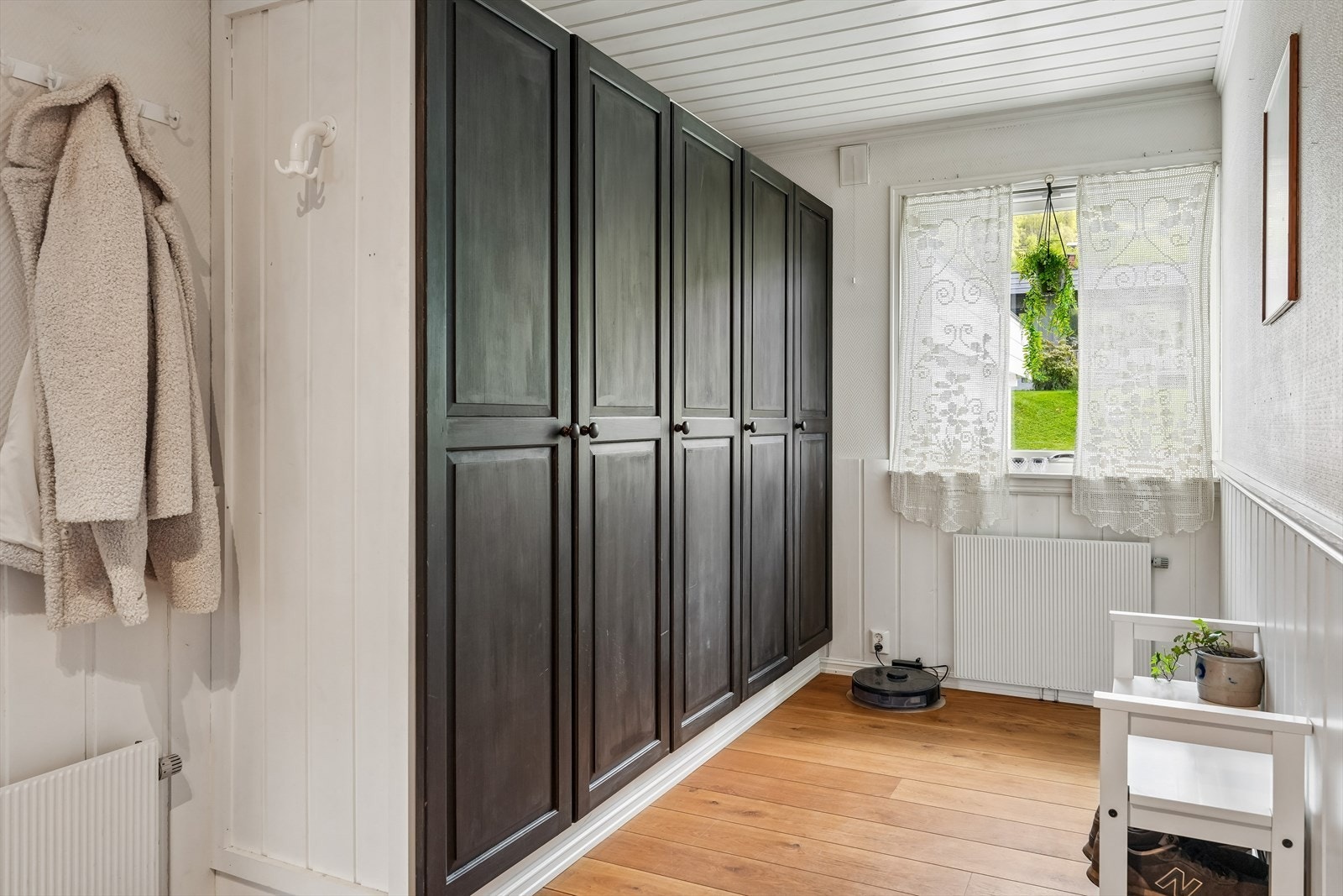 Fra det overbygde inngangspartiet kommer man inn i en romslig entré med stort garderobeskap som gir gode oppbevaringsmuligheter for yttertøy og sko. Galleribilde