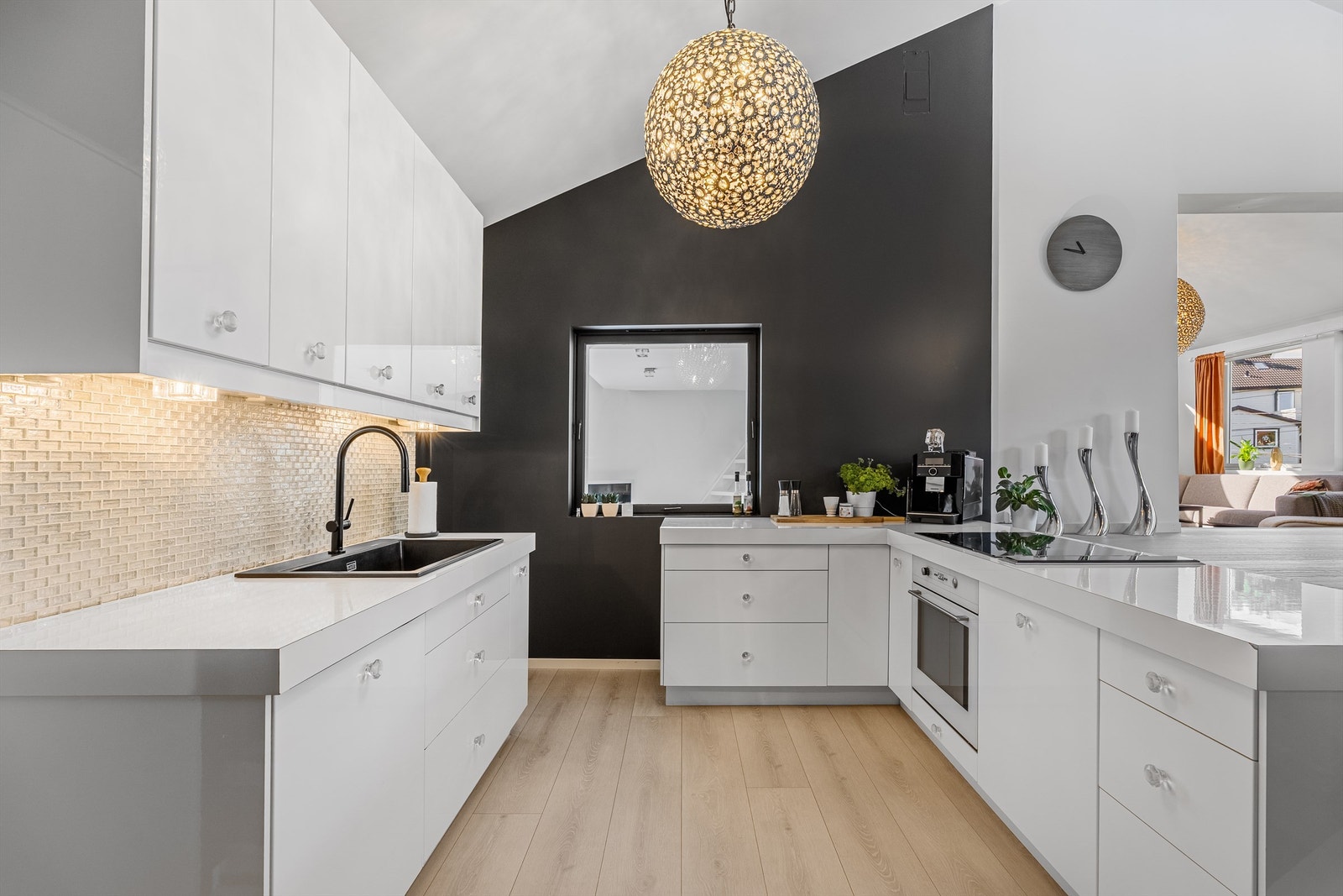 Det er en åpen kjøkken/stue løsning. Kjøkkenet er minimalistisk med hvite slette fronter. Galleribilde