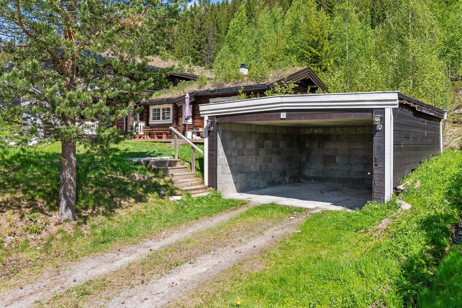 Carport fra 2003 med torvtak og plass til hovedsakelig én bil. Galleribilde