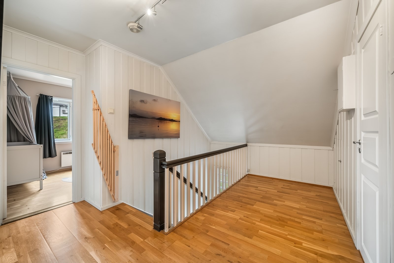Loftsgangen binder sammen soverommene og badet, med vegger kledd i trepanel. Galleribilde